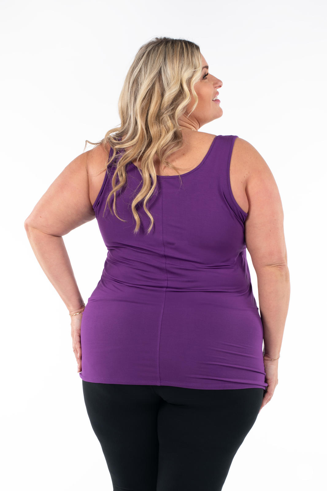 Plus size woman wearing deep purple Classic Layering Tank by SweetLegs Canada shown from back with black leggings on white background