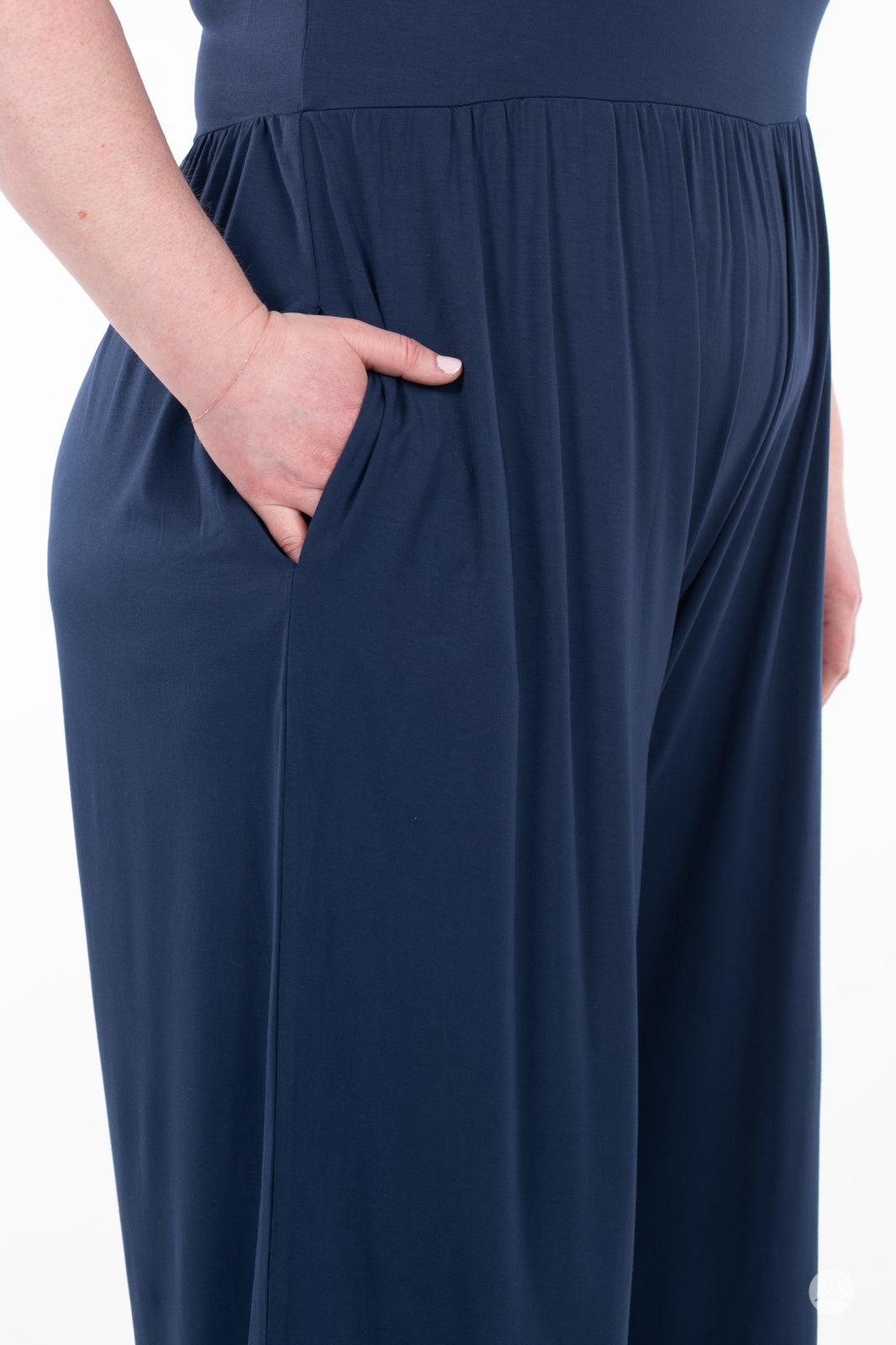 Close-up of hand tucked in side pocket on navy blue SweetLegs Cropped Wide Leg Jumpsuit fabric detail