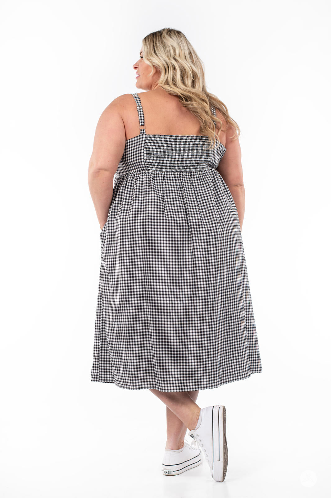 Plus-size model showing back of SweetTops Gingham Dress with adjustable straps in classic black and white pattern