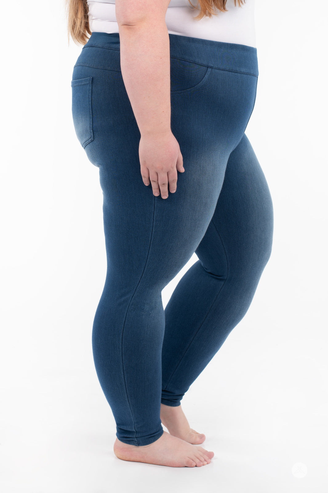 Side view of plus-size model wearing SweetLegs Denim High-Waisted Pocket Leggings in blue with soft stretch fabric