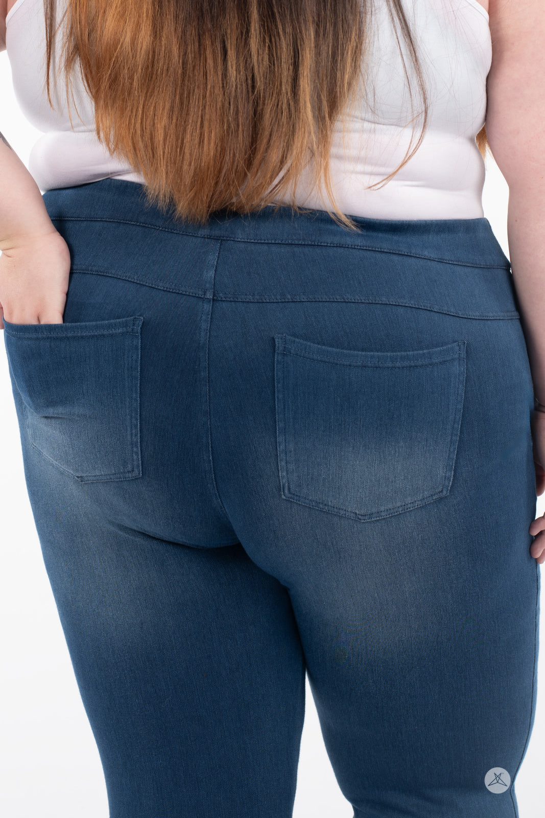 Rear view of plus-size model in SweetLegs Denim High-Waisted Pocket Leggings in blue with real back pockets
