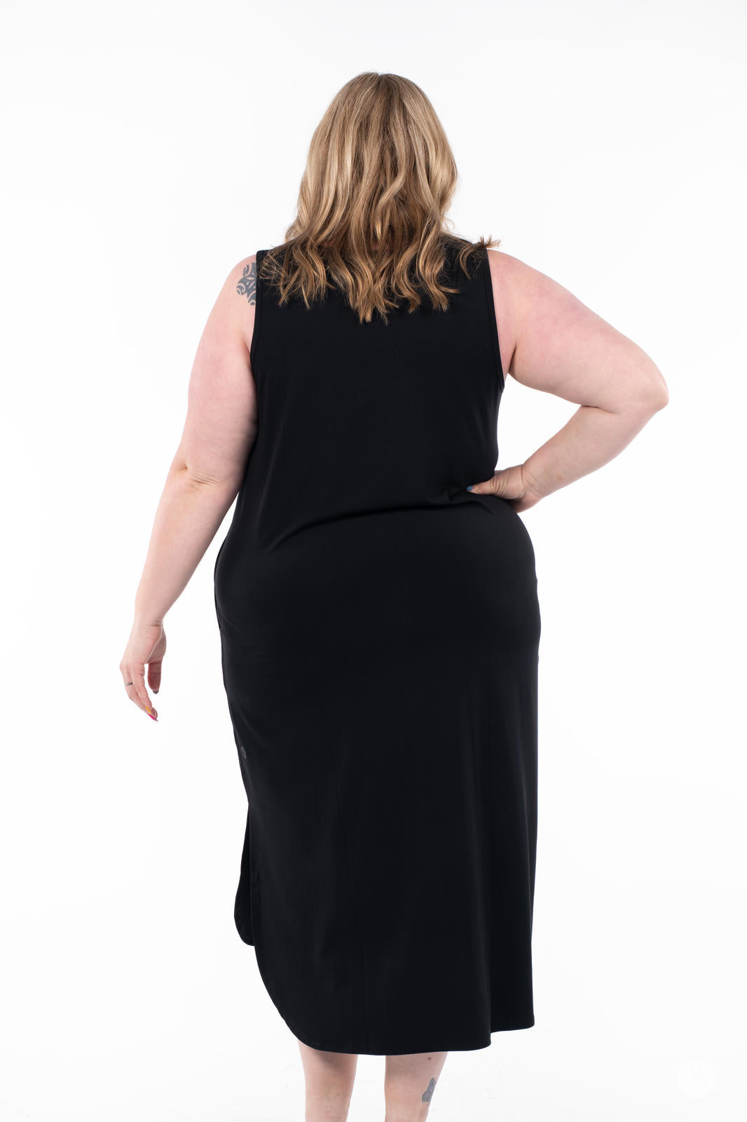 Plus-size woman modeling SweetTops black Sleeveless Tank Dress from the back on white background
