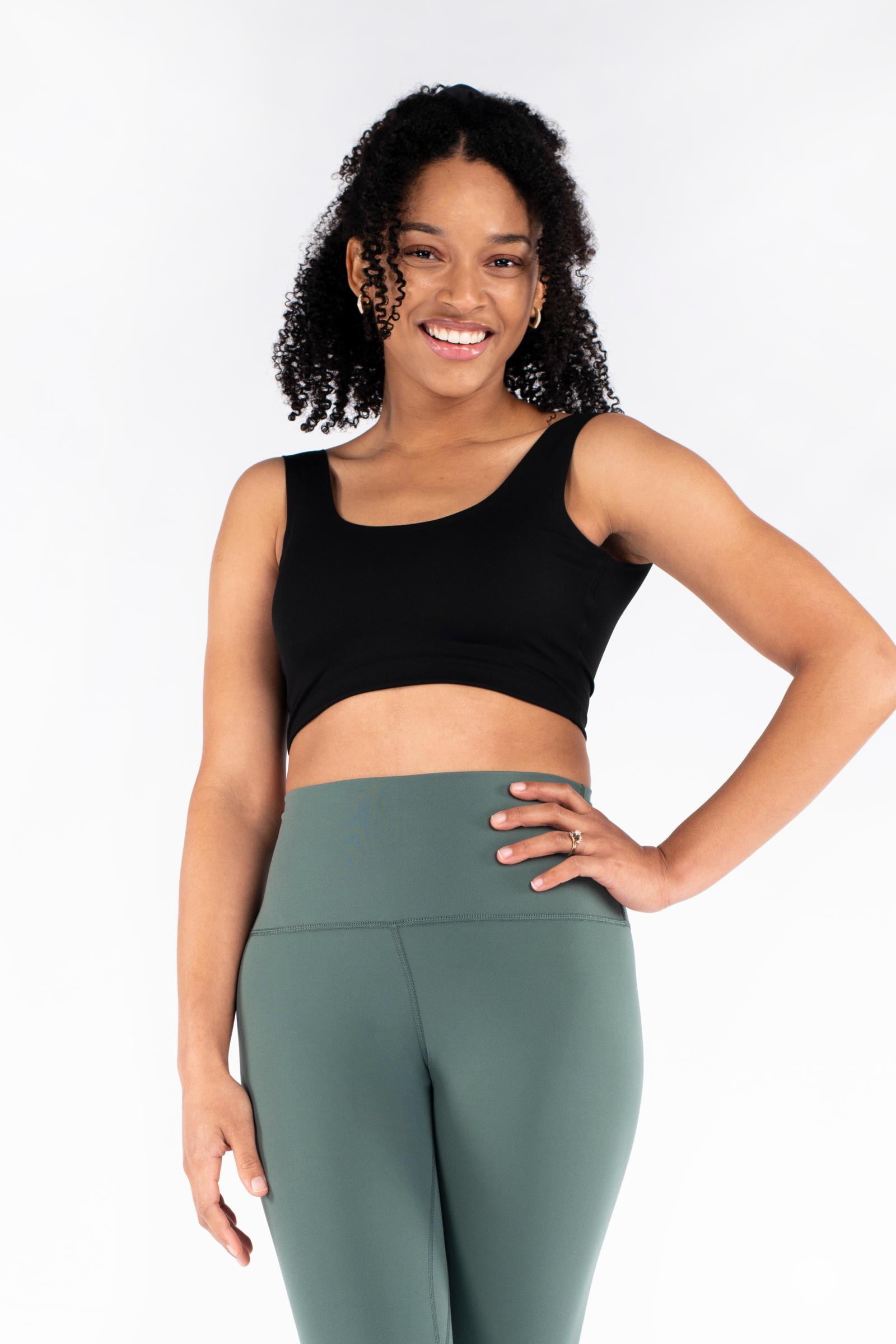 Smiling model wearing green Free Motion Leggings by SweetLegs Athleisure with hand on hip and black crop top