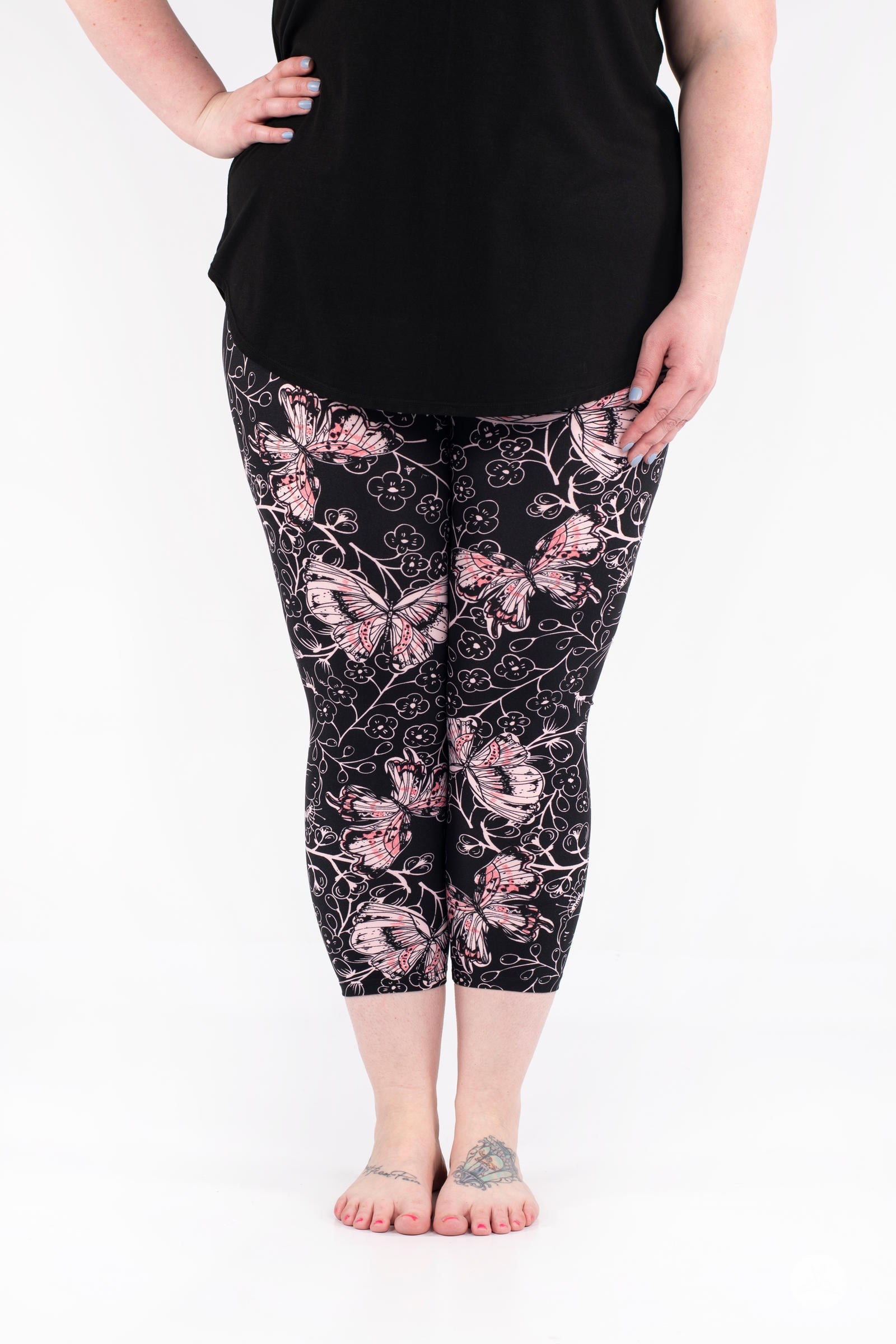 Front view of SweetLegs Butterfly Bliss 2.0 Crops featuring pink butterfly and floral print on black fabric