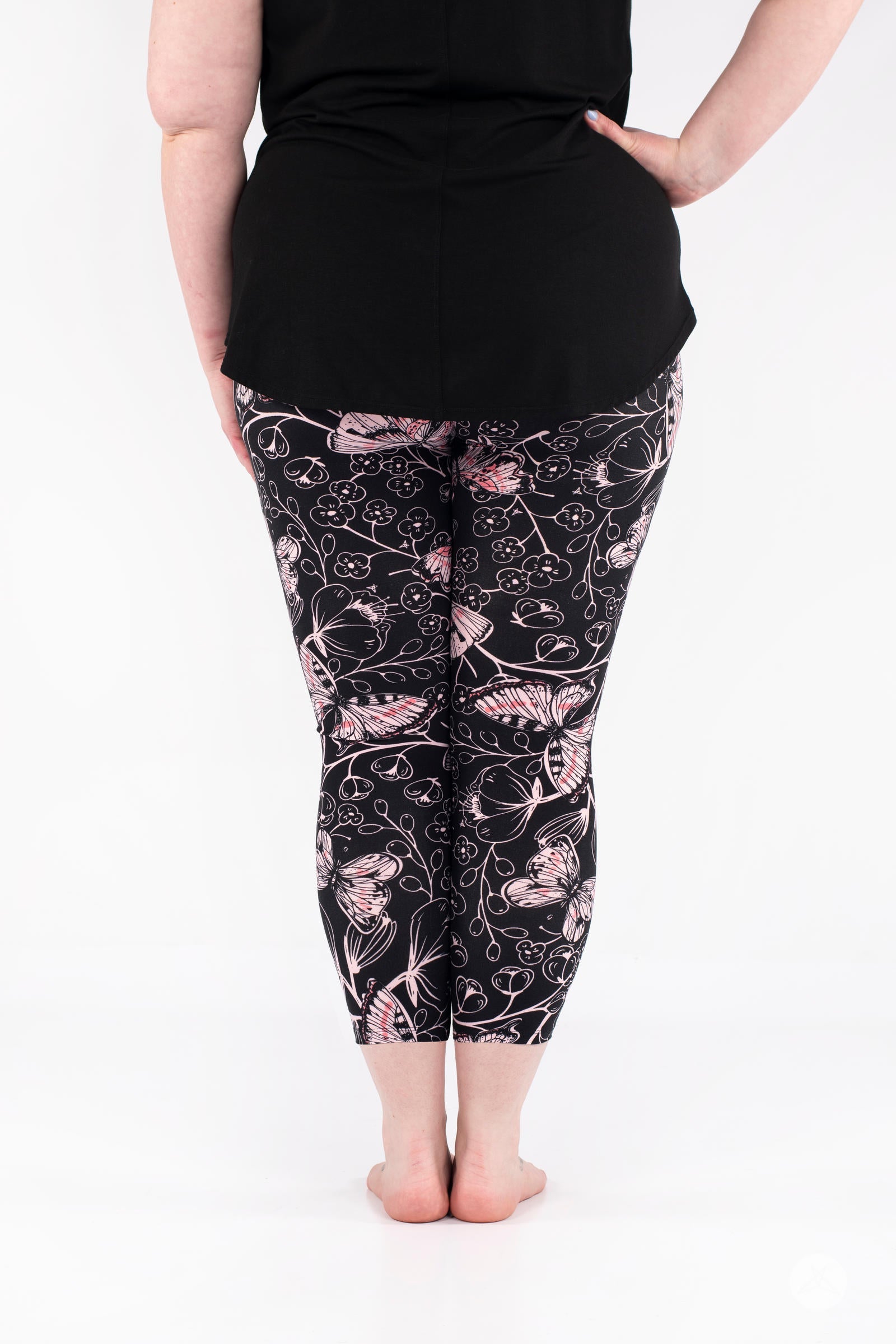 Rear view of plus-size model wearing SweetLegs Butterfly Bliss 2.0 Crops with pink butterfly and floral design