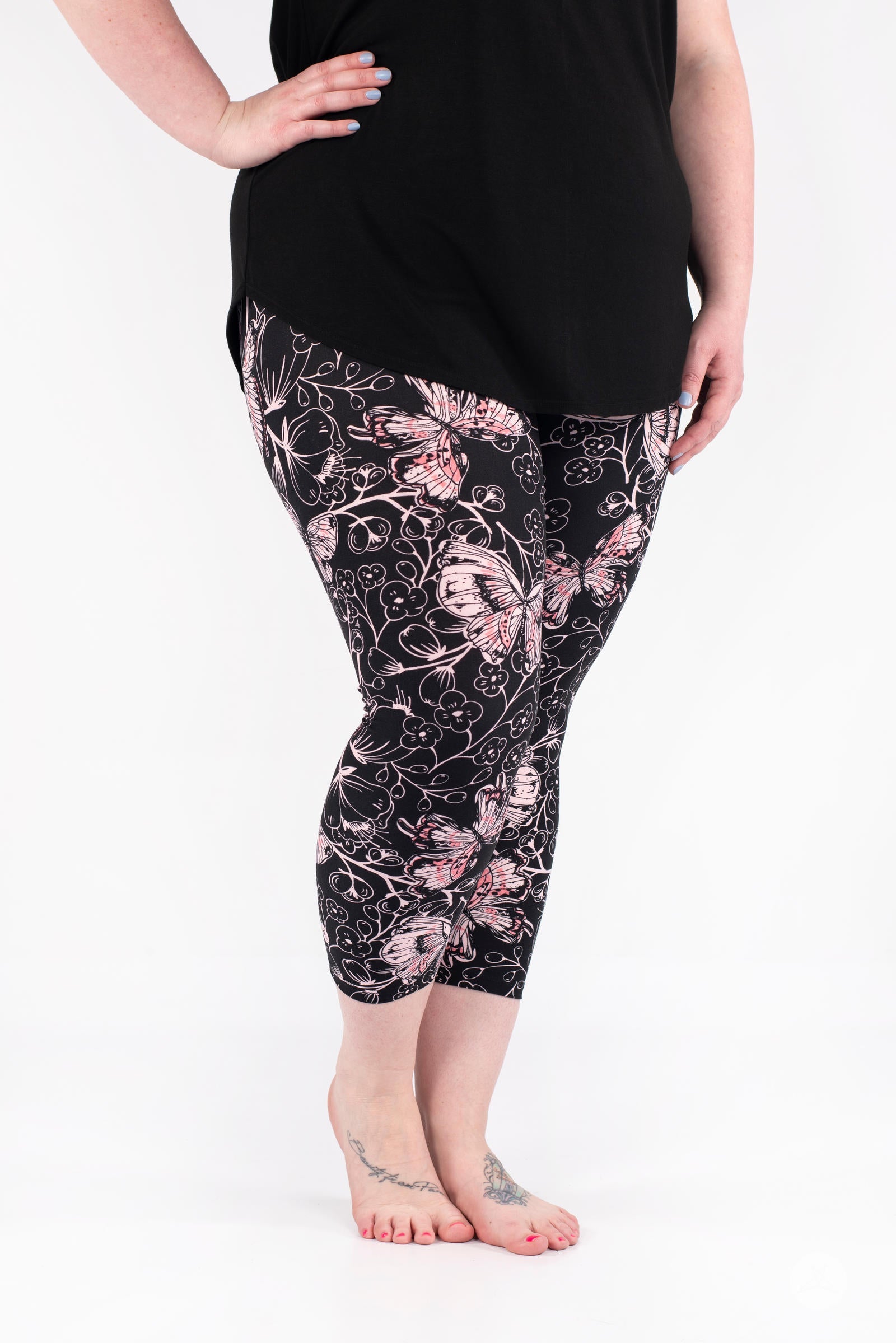 Plus-size model wearing SweetLegs Butterfly Bliss 2.0 Crops with pink butterfly and floral print in cropped length