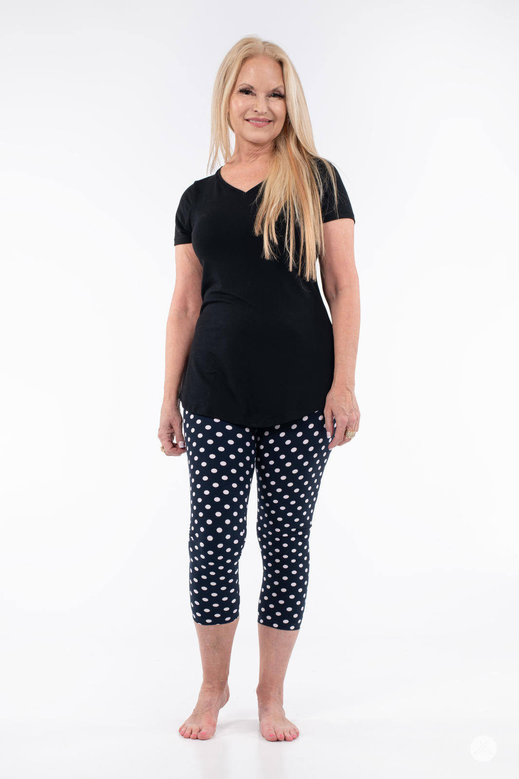 Woman wearing SweetLegs Get Spotted Crops in navy with white polka dots paired with black top on white background