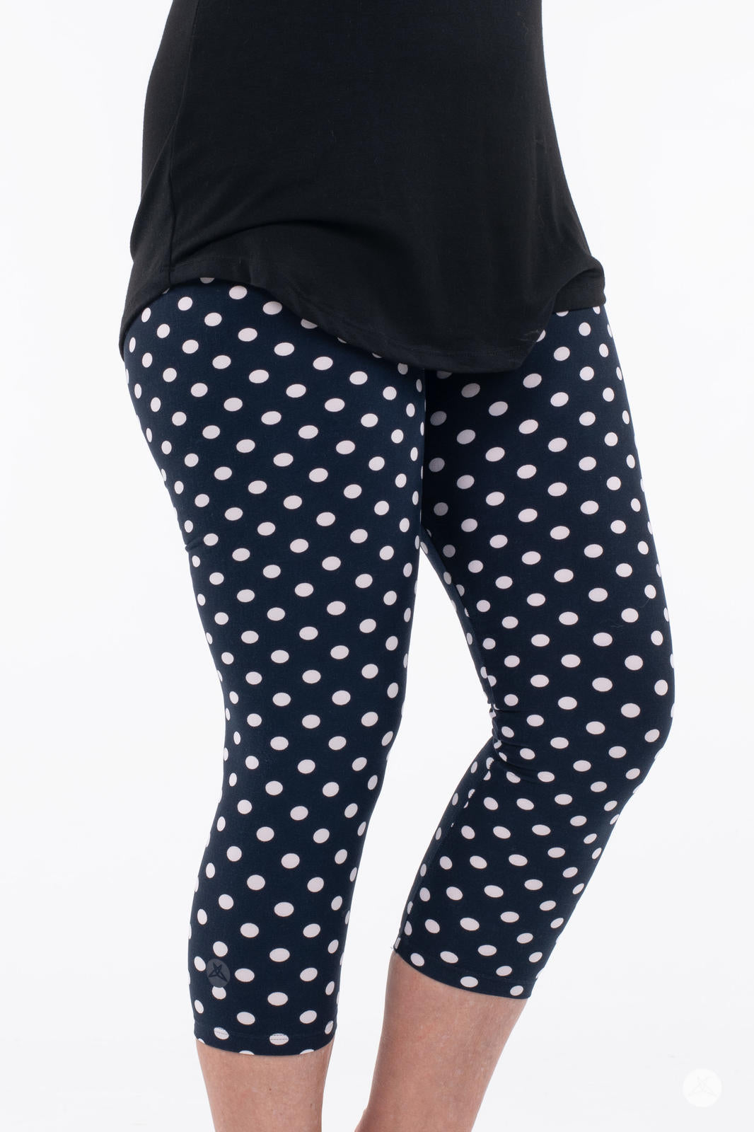 Close-up of SweetLegs Get Spotted Crops showing navy leggings with white polka dots and black top on white background