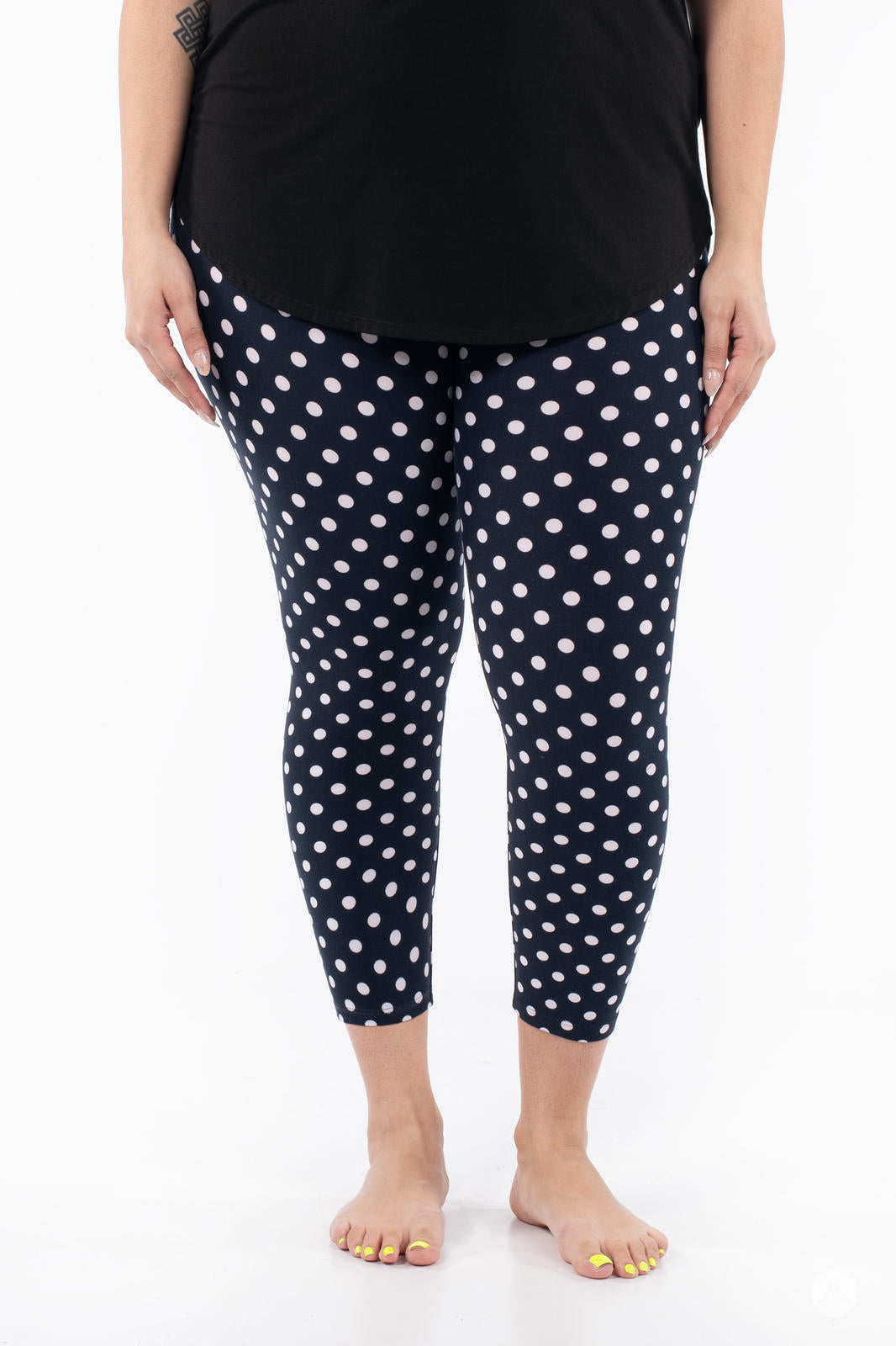 Front view of SweetLegs Get Spotted Crops in navy with white polka dots worn with a black top on white background
