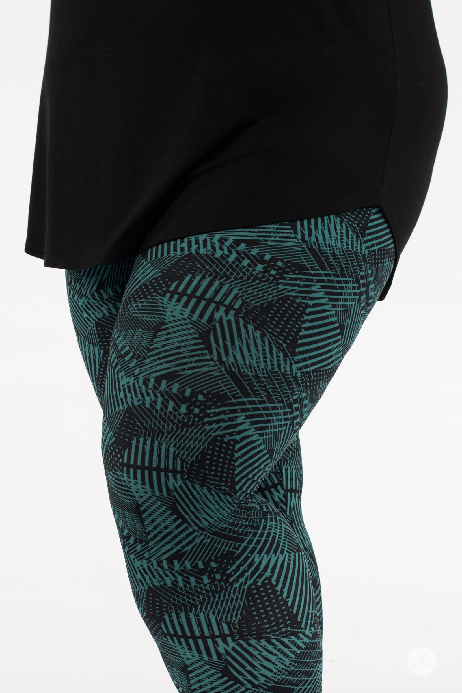Close-up of SweetLegs Geometric Glam Crops showing teal and black abstract patterned cropped leggings with a black top