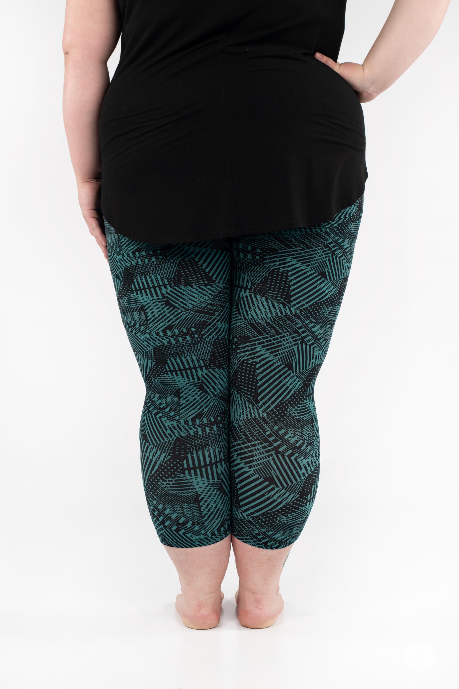 Rear view of SweetLegs Geometric Glam Crops in green and black geometric pattern cropped leggings on model