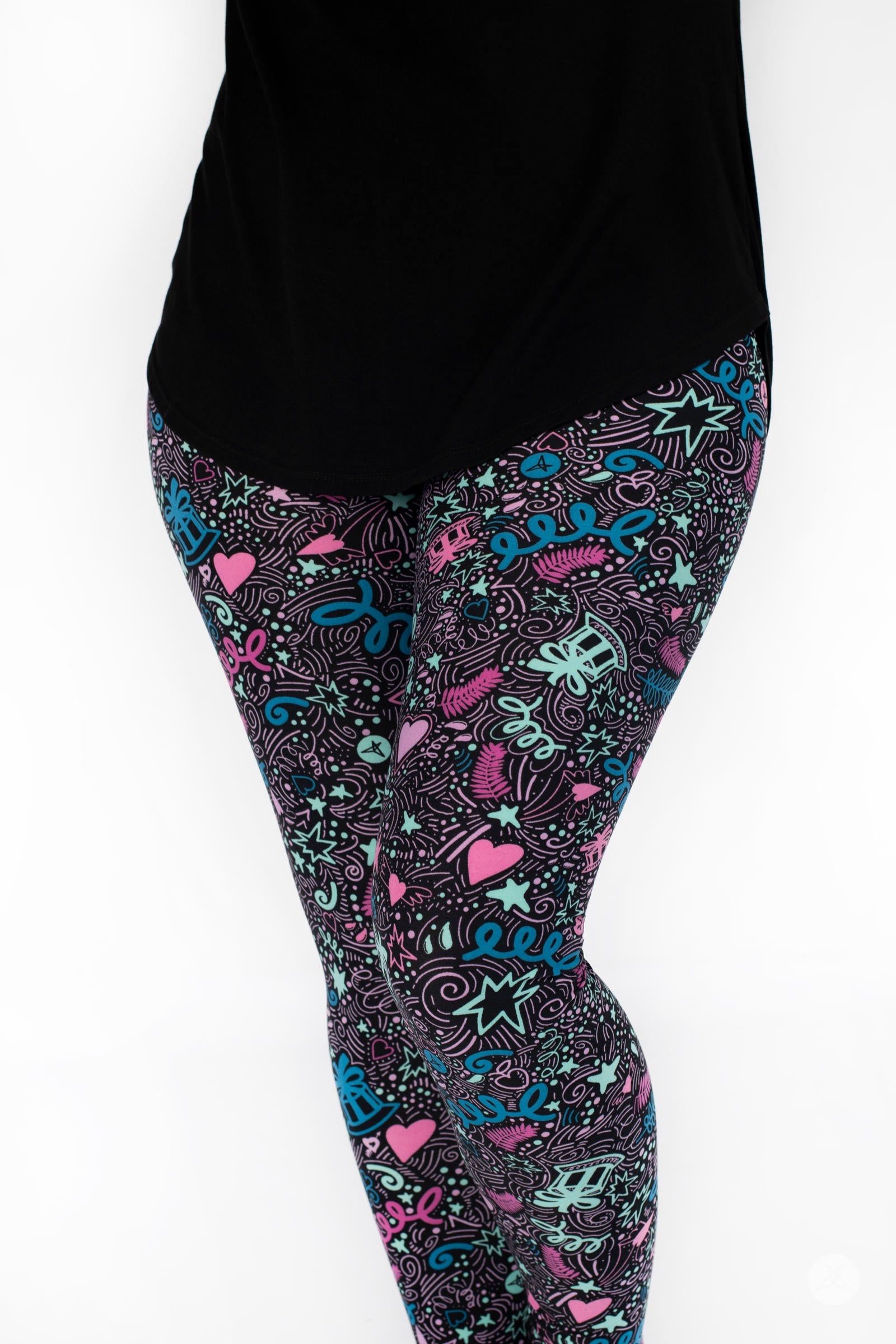 Front view of legs wearing SweetLegs Partylicious leggings with colorful party print paired with black top on white background