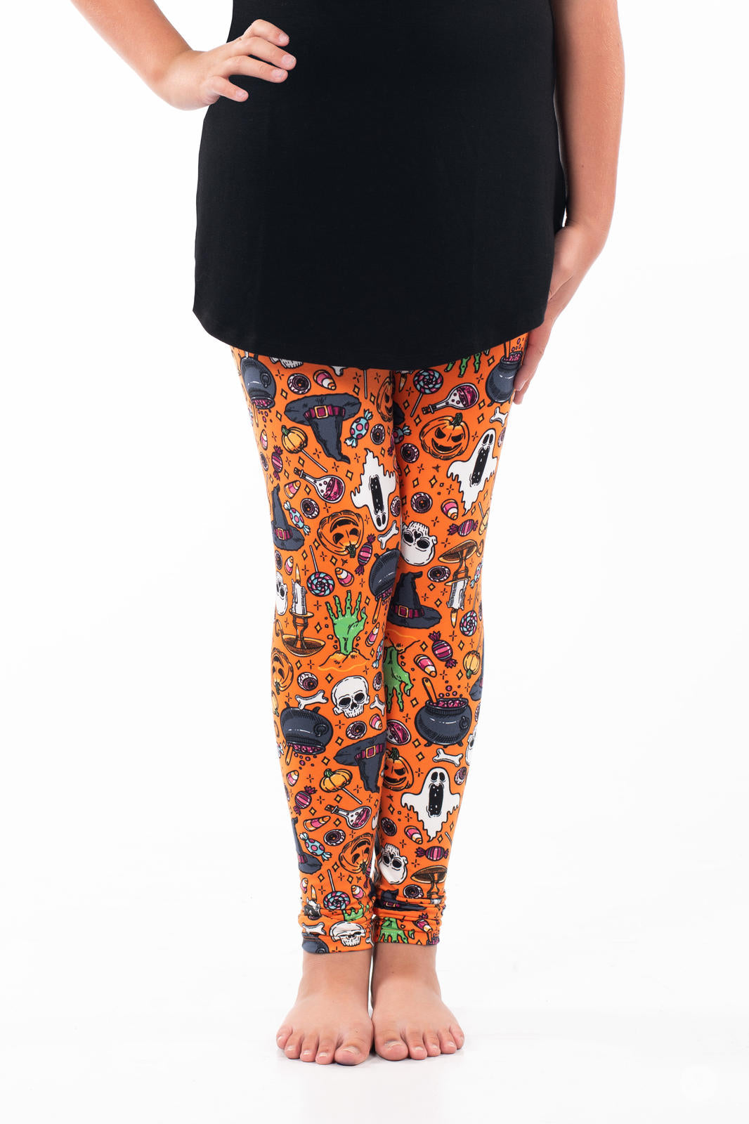 Kids wearing SweetLegs Treats No Tricks Kids leggings with colorful Halloween icons on bright orange background