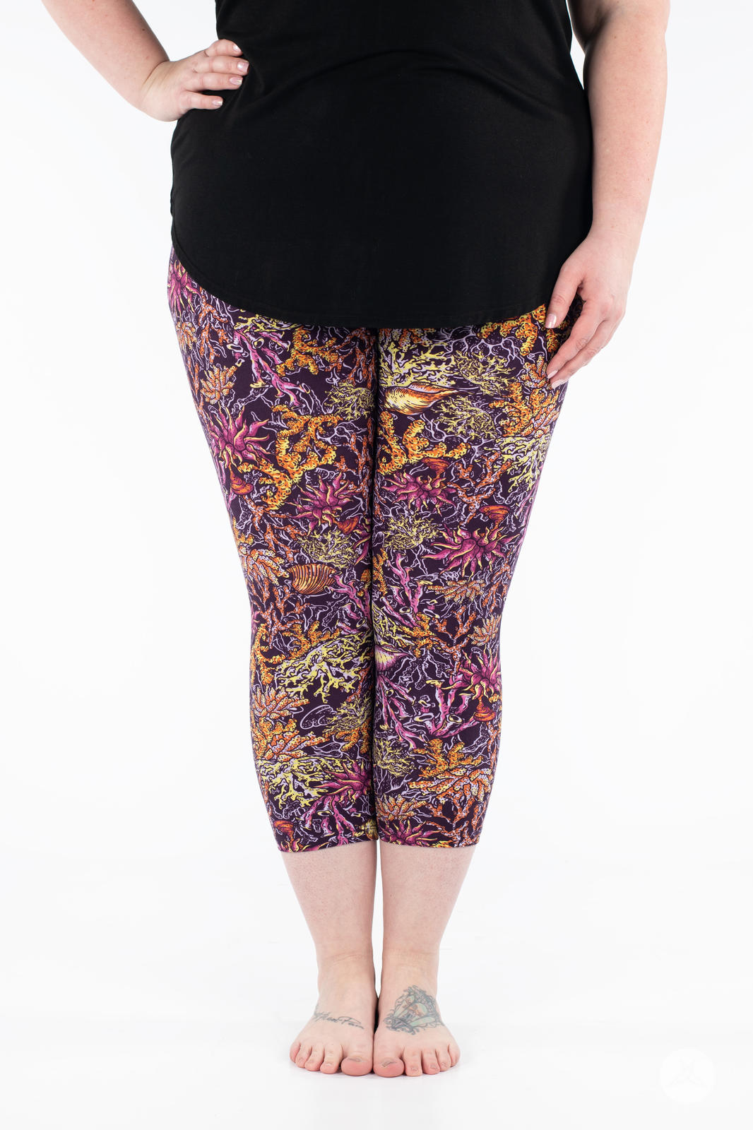 Front view of plus size model wearing SweetLegs Coral Cove Crops with vibrant coral reef print cropped above the ankle