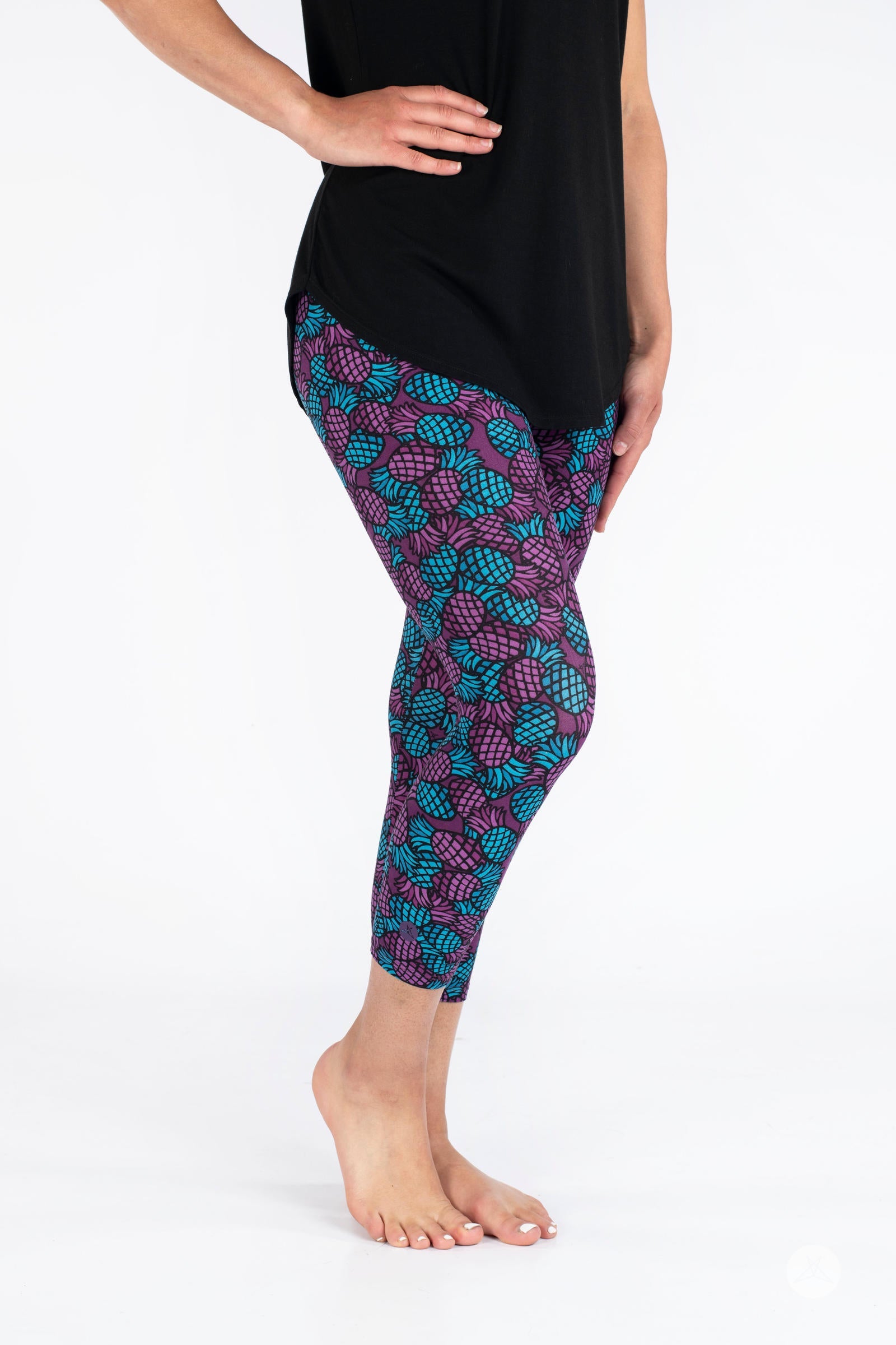 Side view of SweetLegs Razzle Dazzle Crops in purple and teal pineapple pattern on cropped leggings