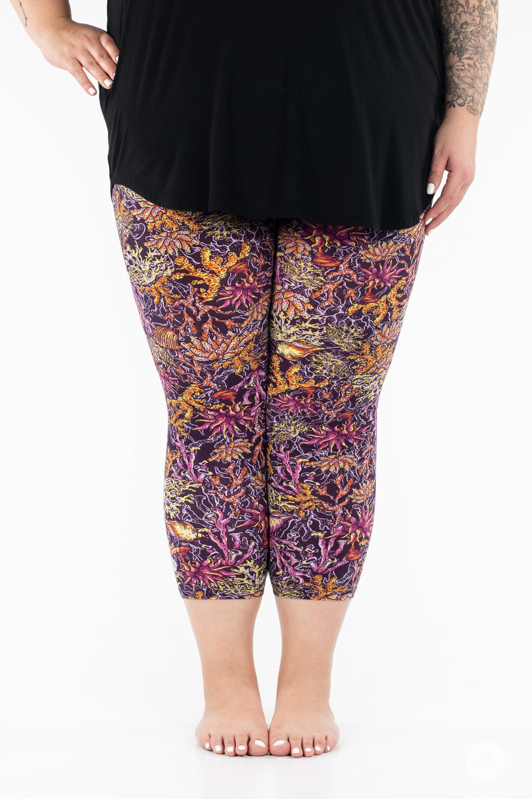 Front view of SweetLegs Coral Cove Crops with colorful coral reef pattern cropped above the ankle on plus size model