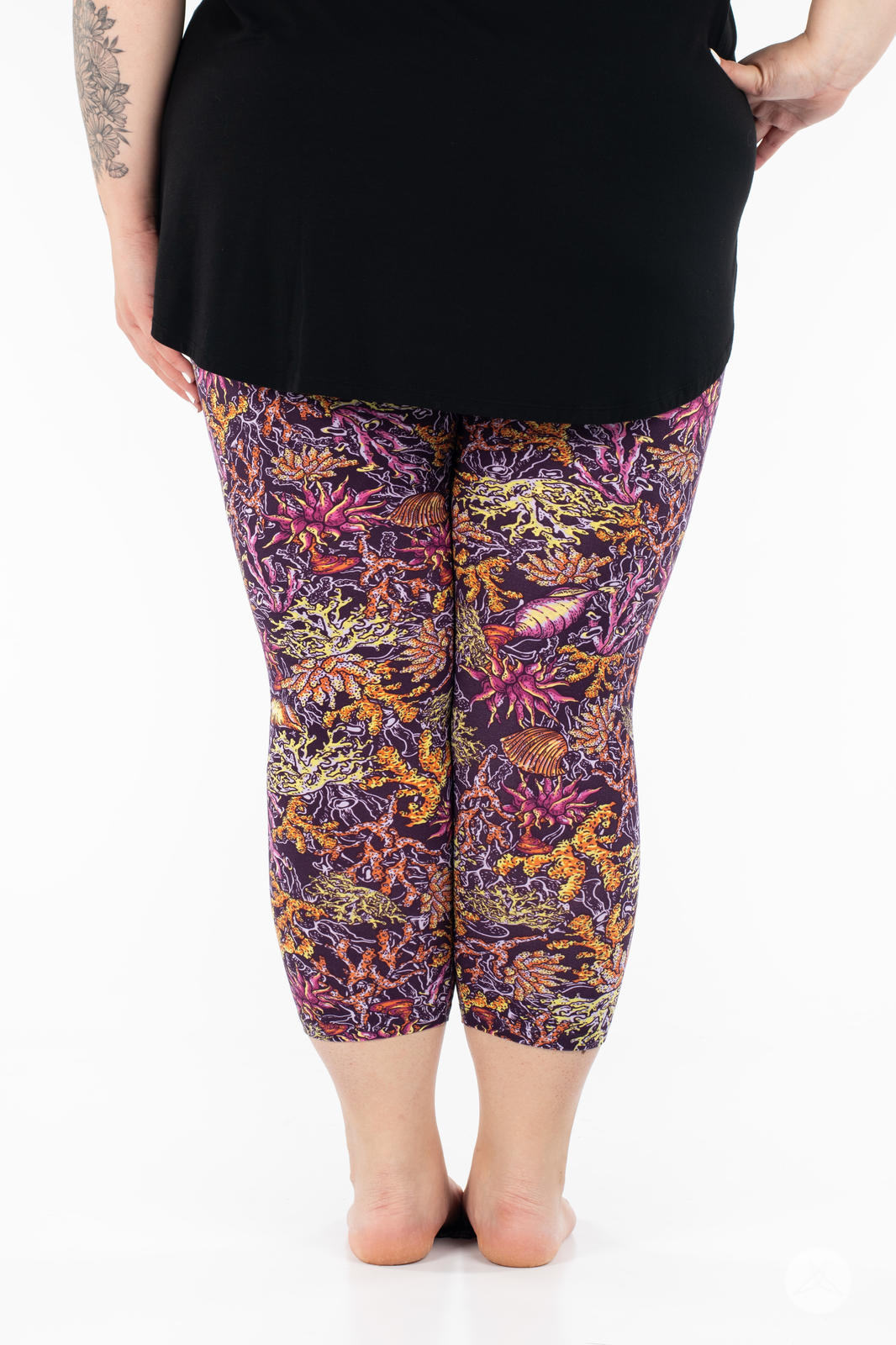 Rear view of plus size model wearing SweetLegs Coral Cove Crops with colorful marine-inspired print cropped above the ankle