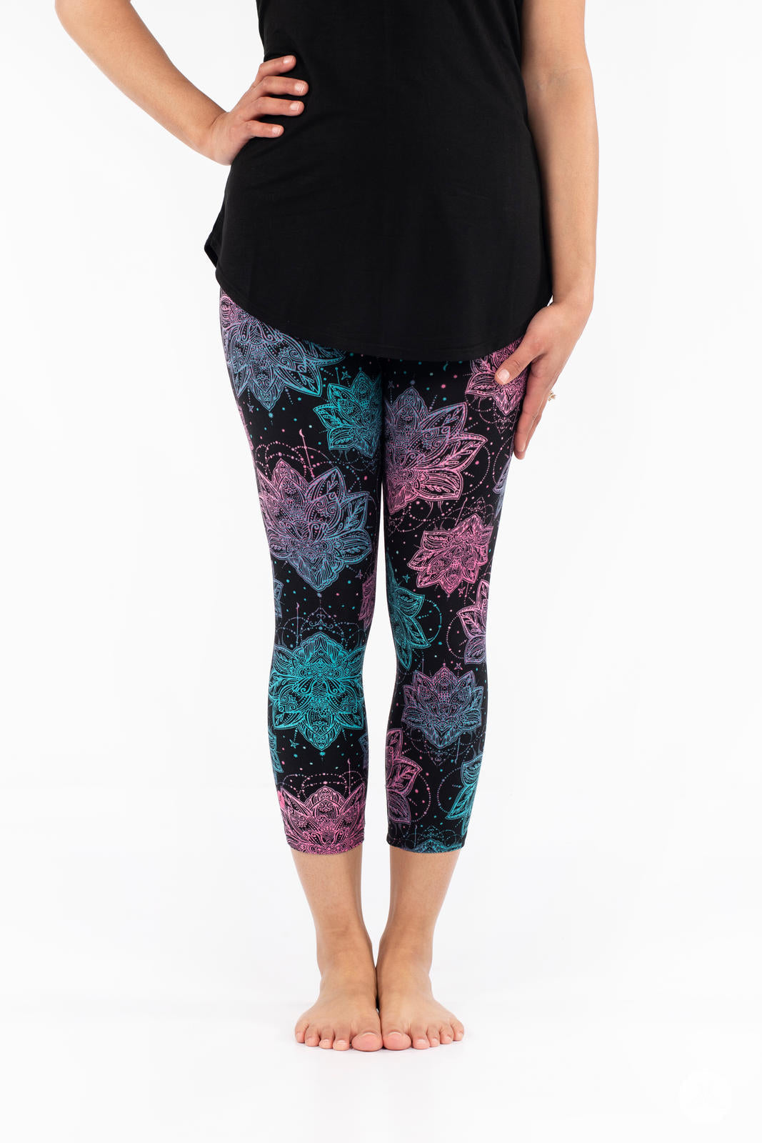 Front view of SweetLegs Everafter Crops with pink, purple, and teal large floral patterns on black background worn by model