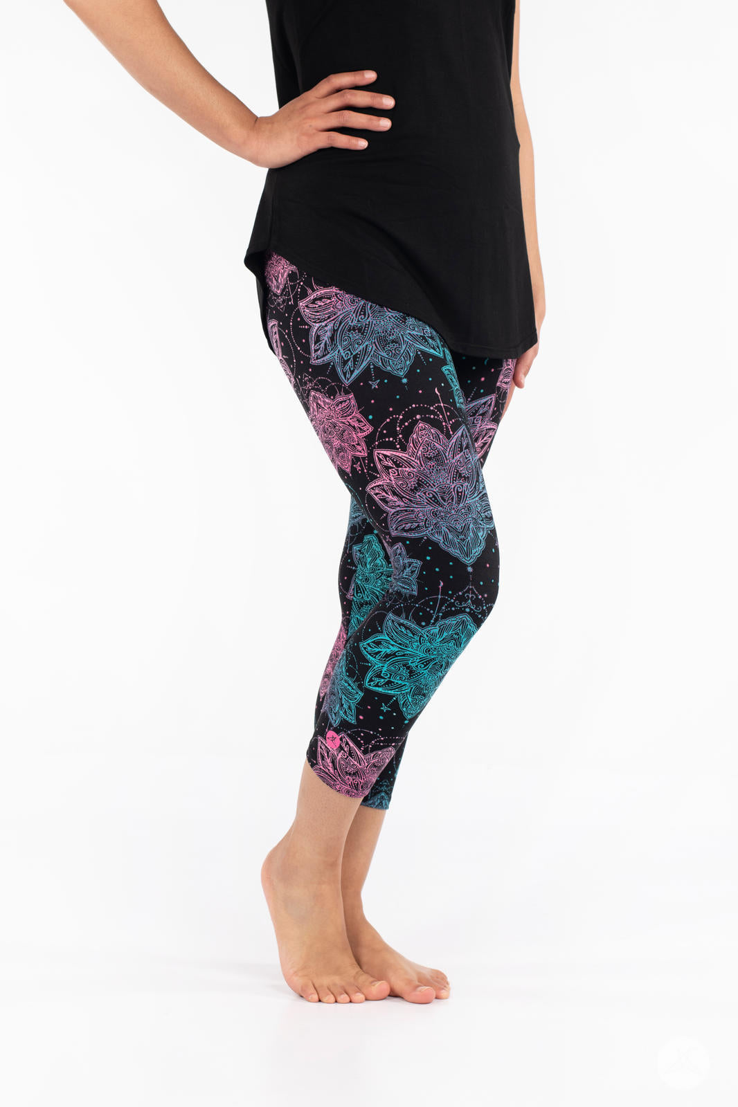 Side view of SweetLegs Everafter Crops with large blue and pink floral patterns on black background worn by model