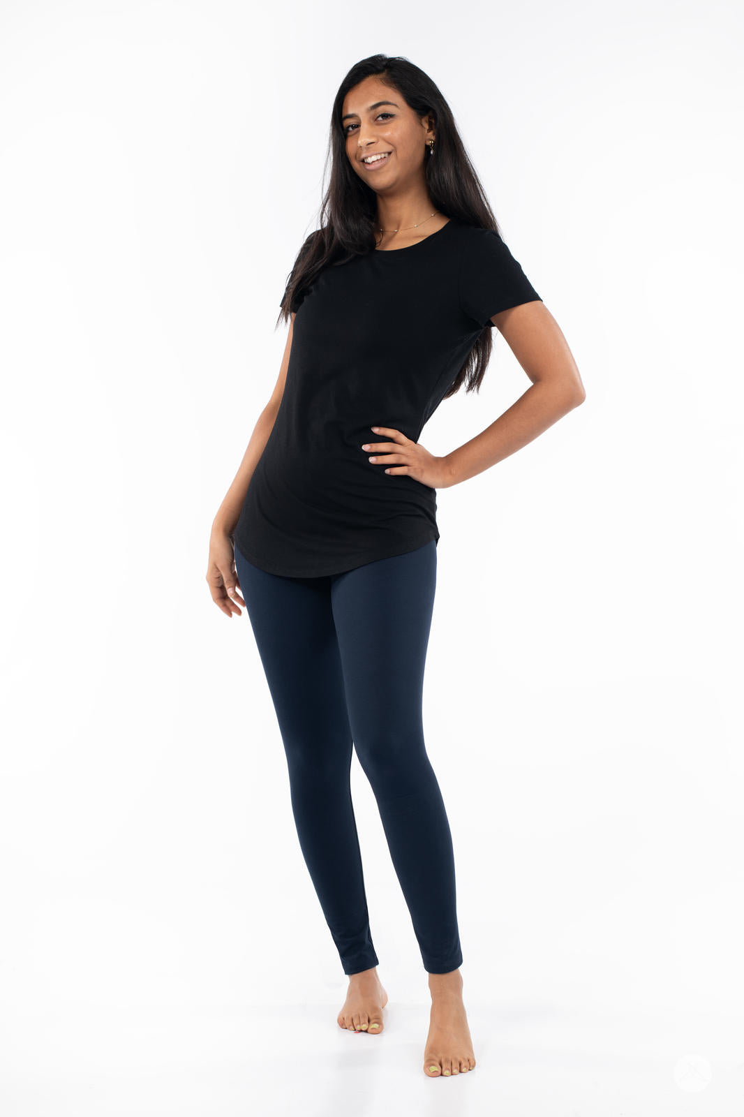 Woman wearing Navy leggings by SweetLegs with black top standing barefoot against white background
