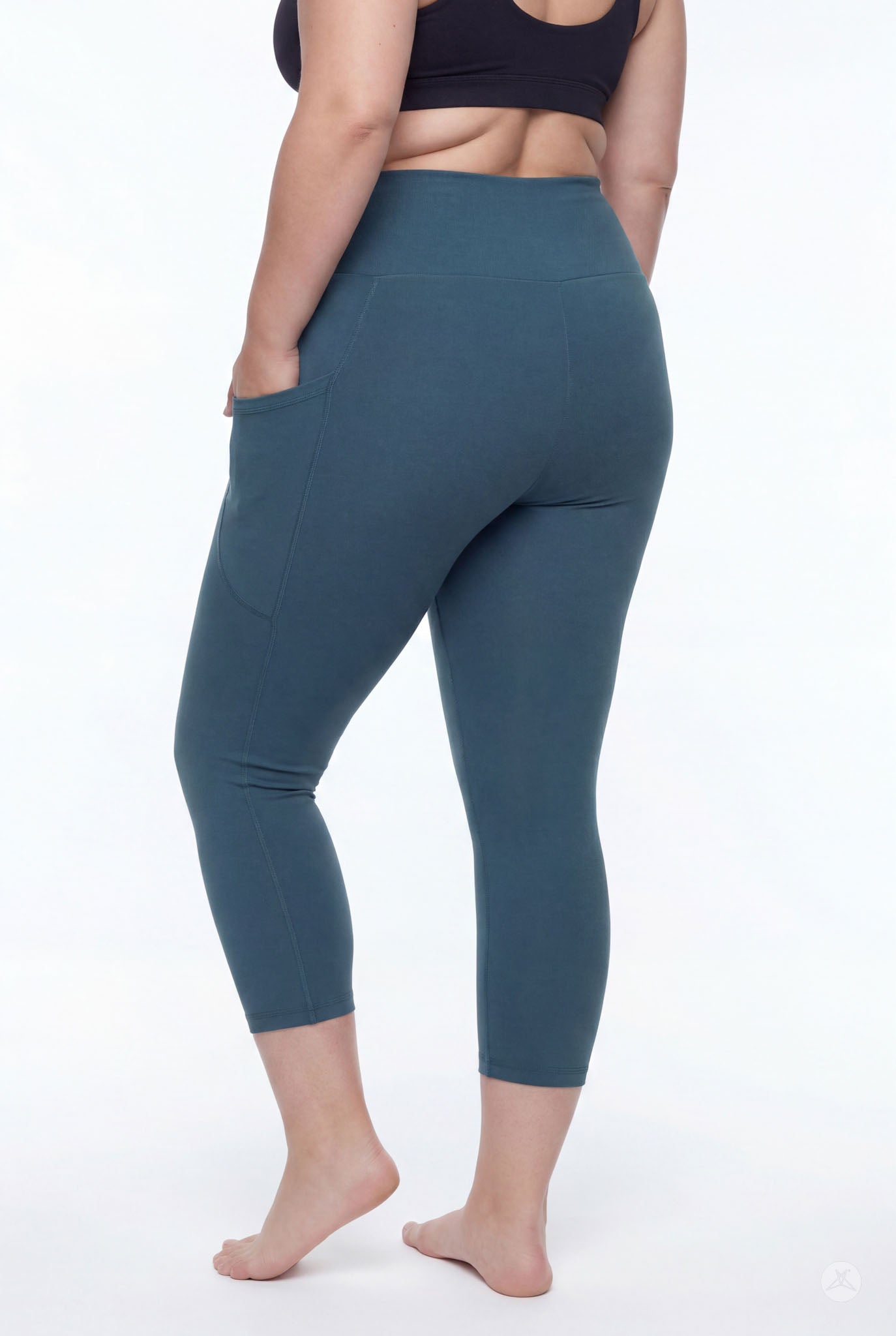 Plus size model barefoot wearing SweetLegs Deep Teal High-Waisted Pocket Crops with hand in side pocket back view