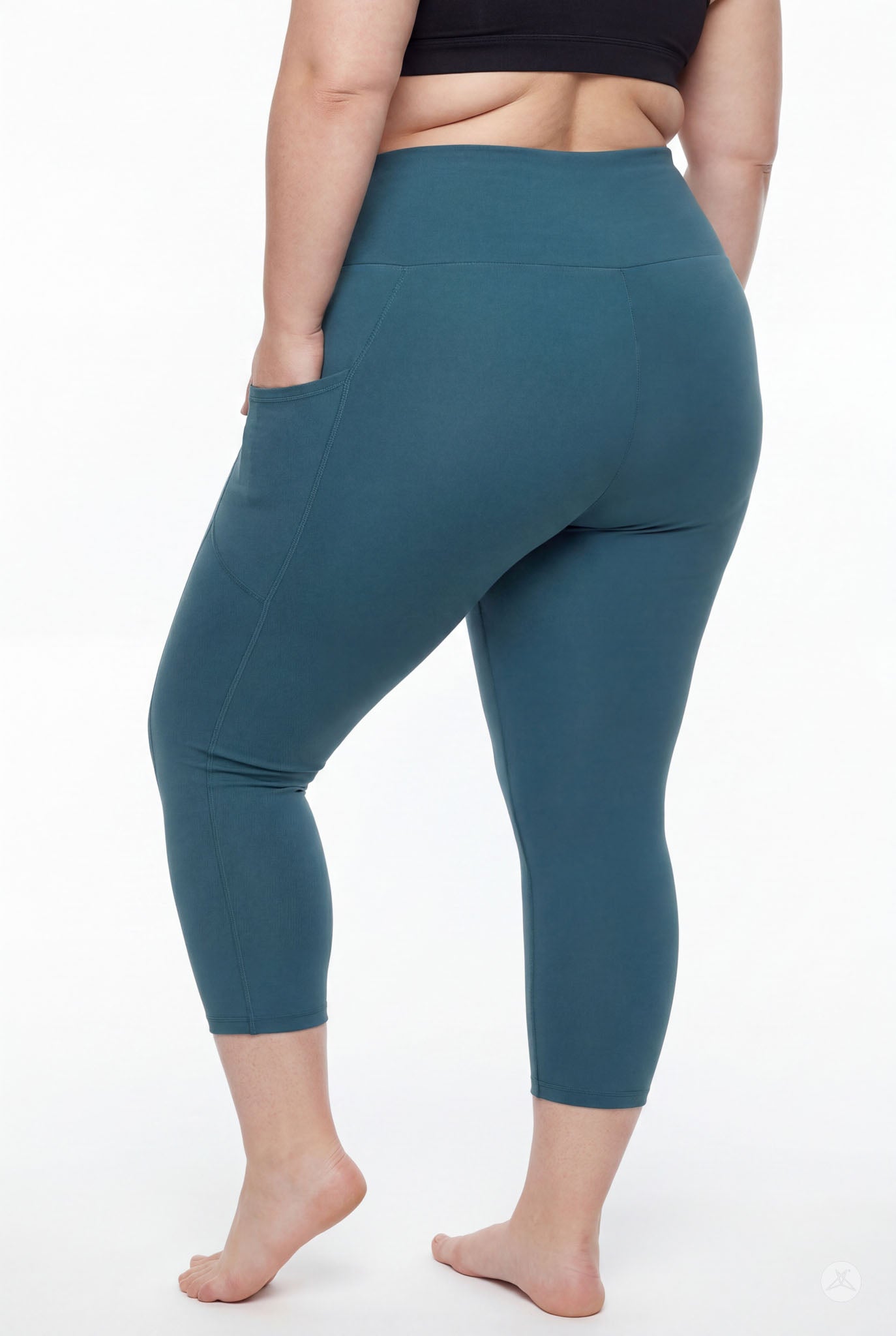 Plus size model barefoot wearing SweetLegs Deep Teal High-Waisted Pocket Crops with hand in side pocket back view
