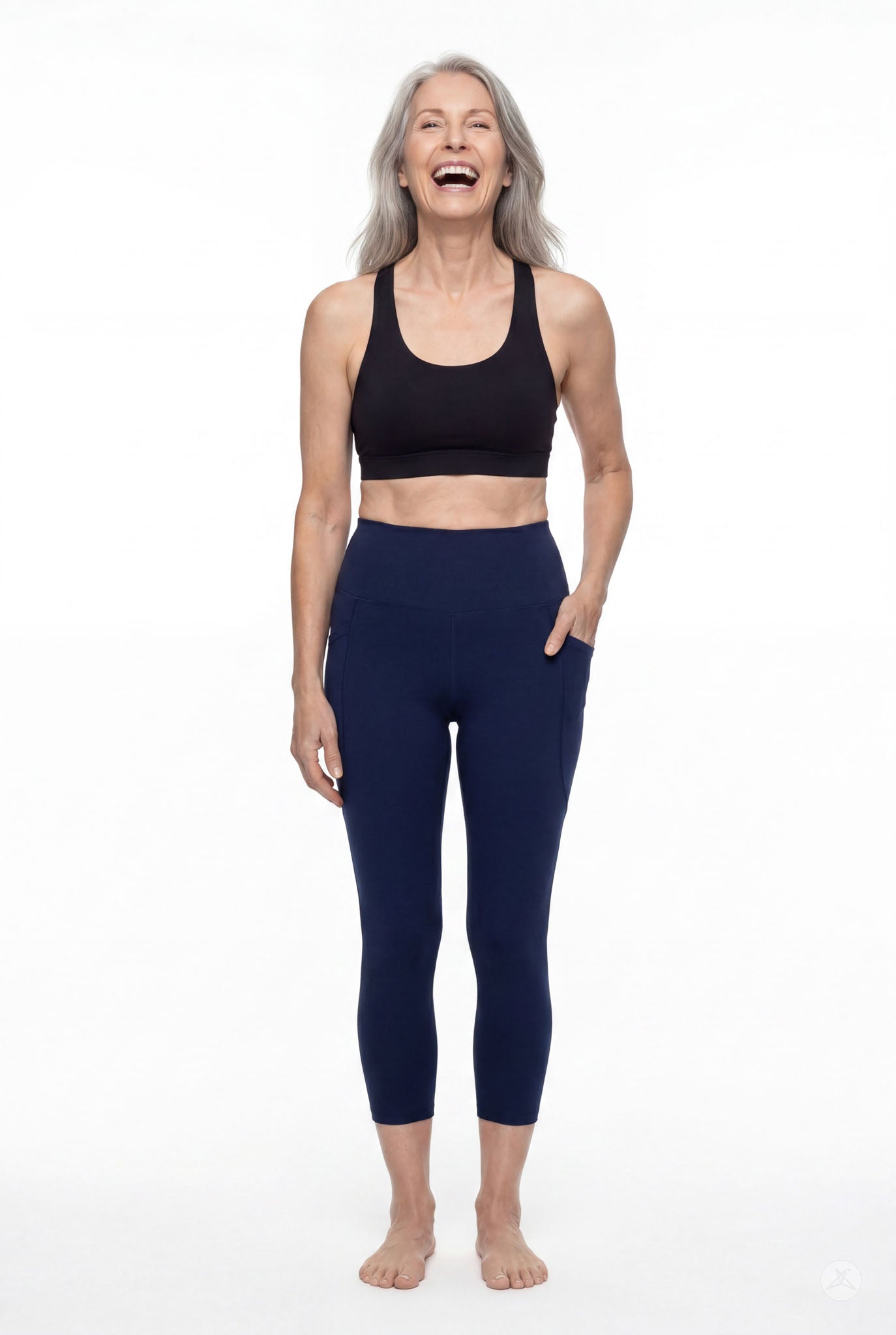 Mature woman smiling wearing SweetLegs Still Water High-Waisted Pocket Crops with side pockets and black sports bra