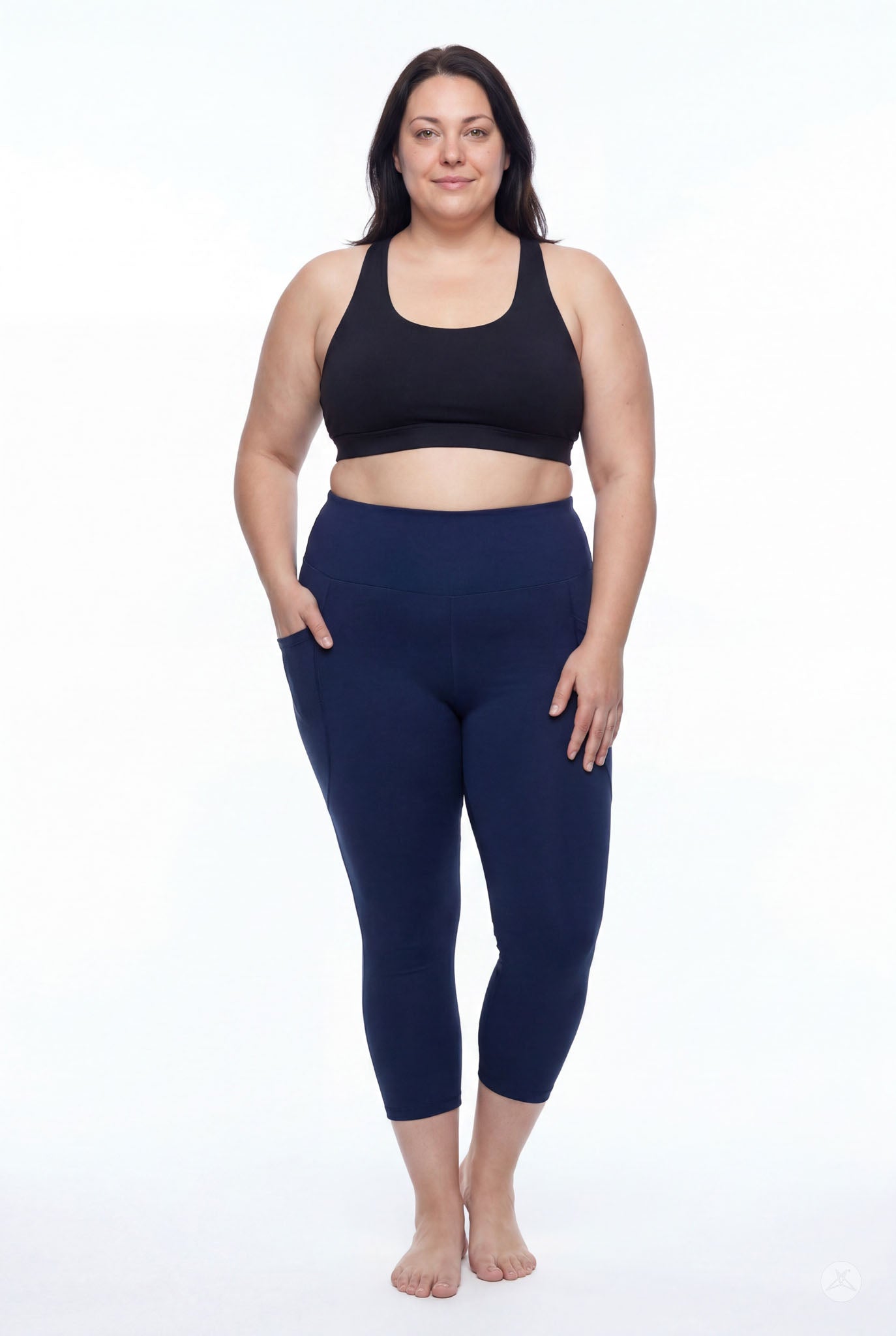 Plus size model wearing SweetLegs Still Water High-Waisted Pocket Crops in navy with black sports bra front view barefoot