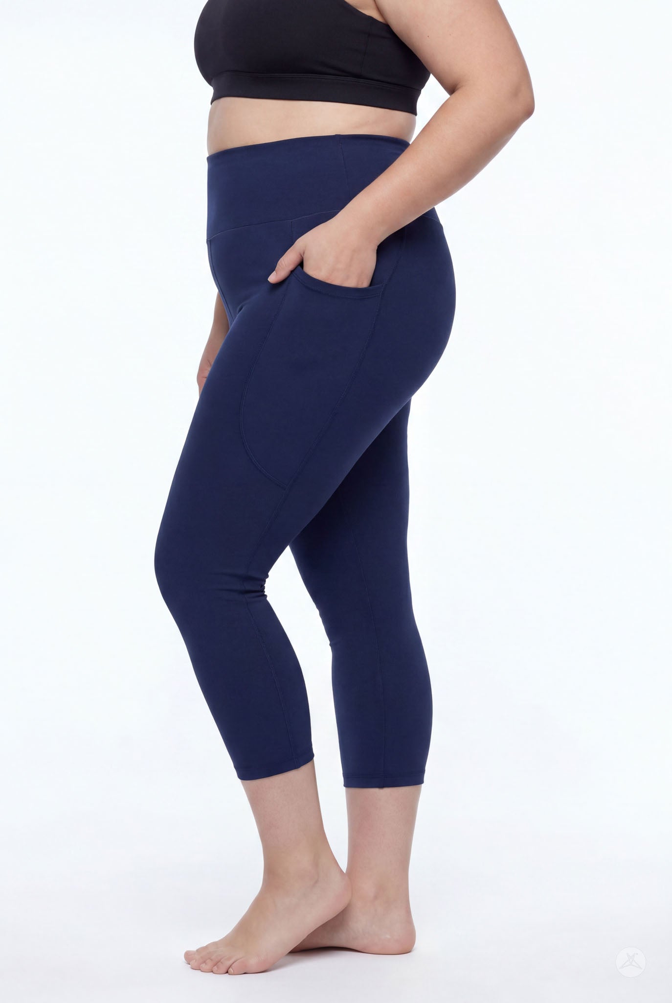 Plus size woman wearing SweetLegs Still Water High-Waisted Pocket Crops in navy with hand in side pocket barefoot side view