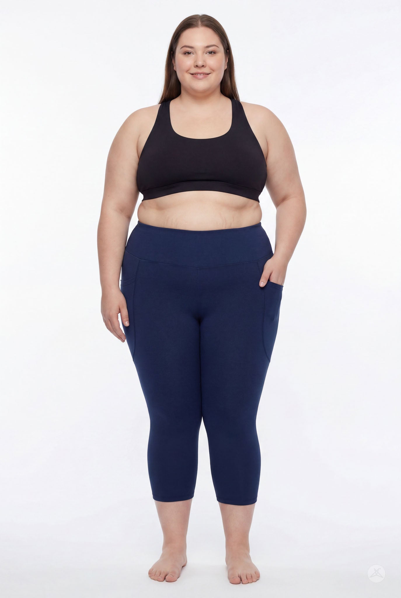 Plus size model wearing SweetLegs Still Water High-Waisted Pocket Crops in navy with black sports bra front view barefoot