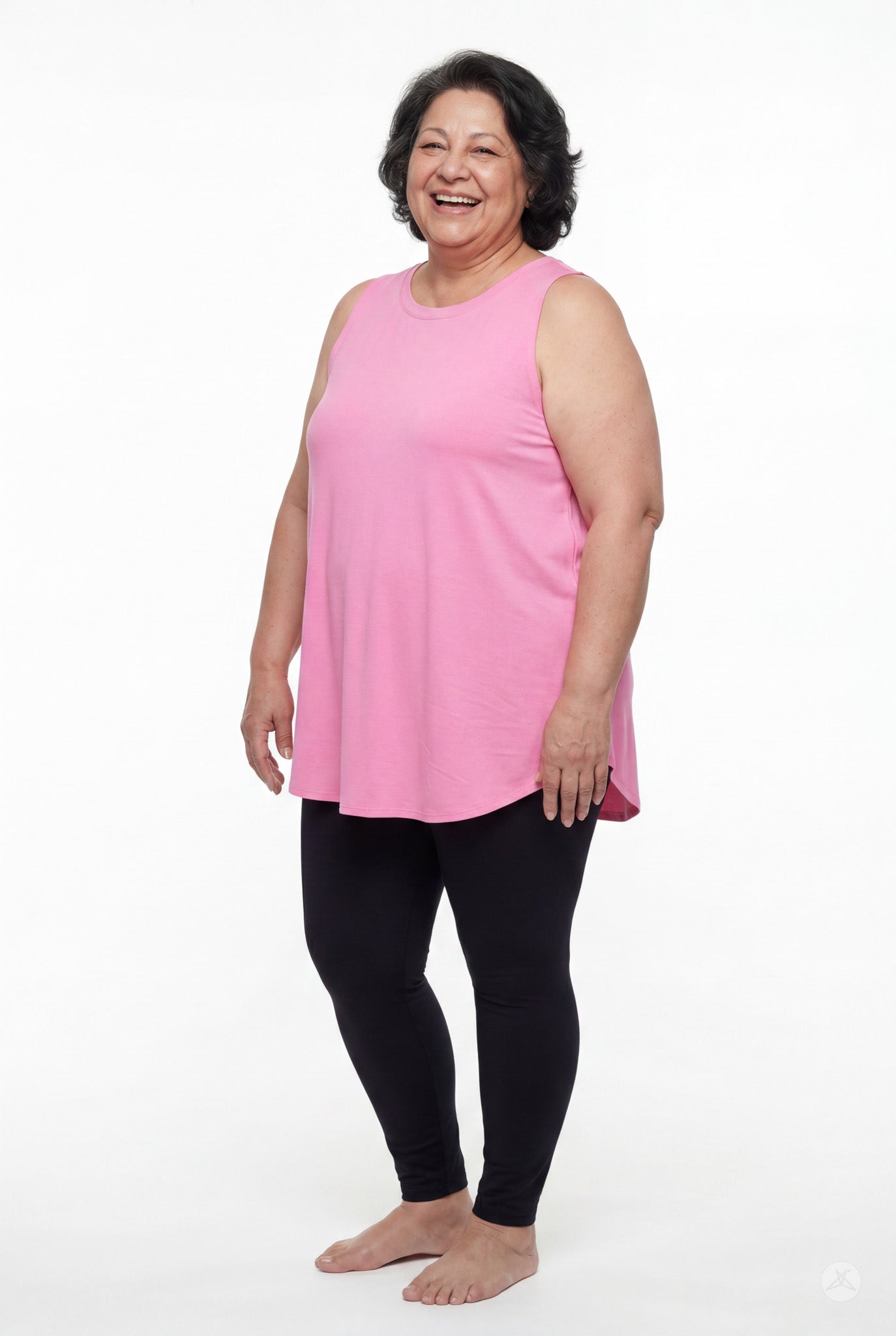 Smiling plus size woman wearing SweetTops High Neck Swing Tank in pink paired with black leggings standing barefoot