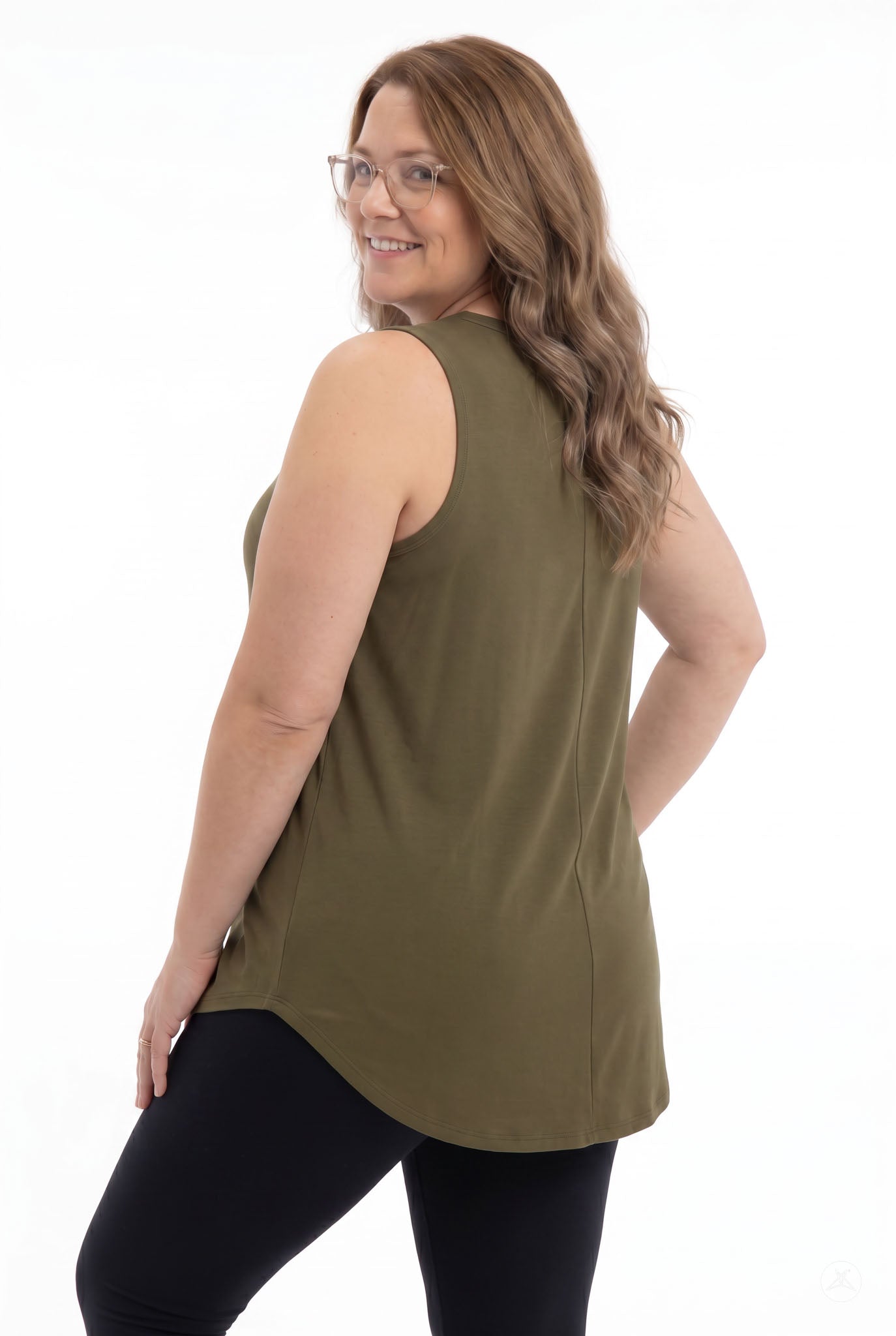 Plus size woman smiling over shoulder wearing olive High Neck Swing Tank by SweetTops with black leggings on white background