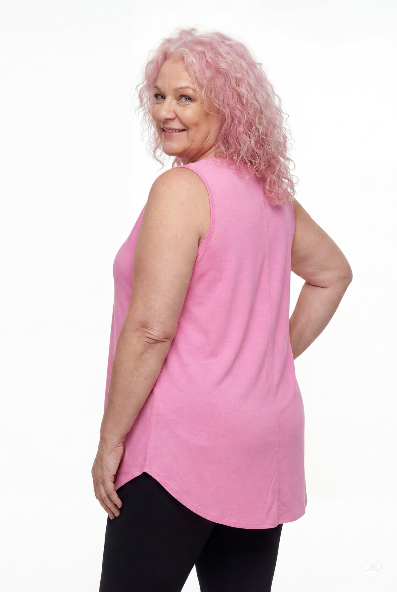 Woman smiling over shoulder wearing SweetTops High Neck Swing Tank in pink with relaxed fit and sleeveless cut