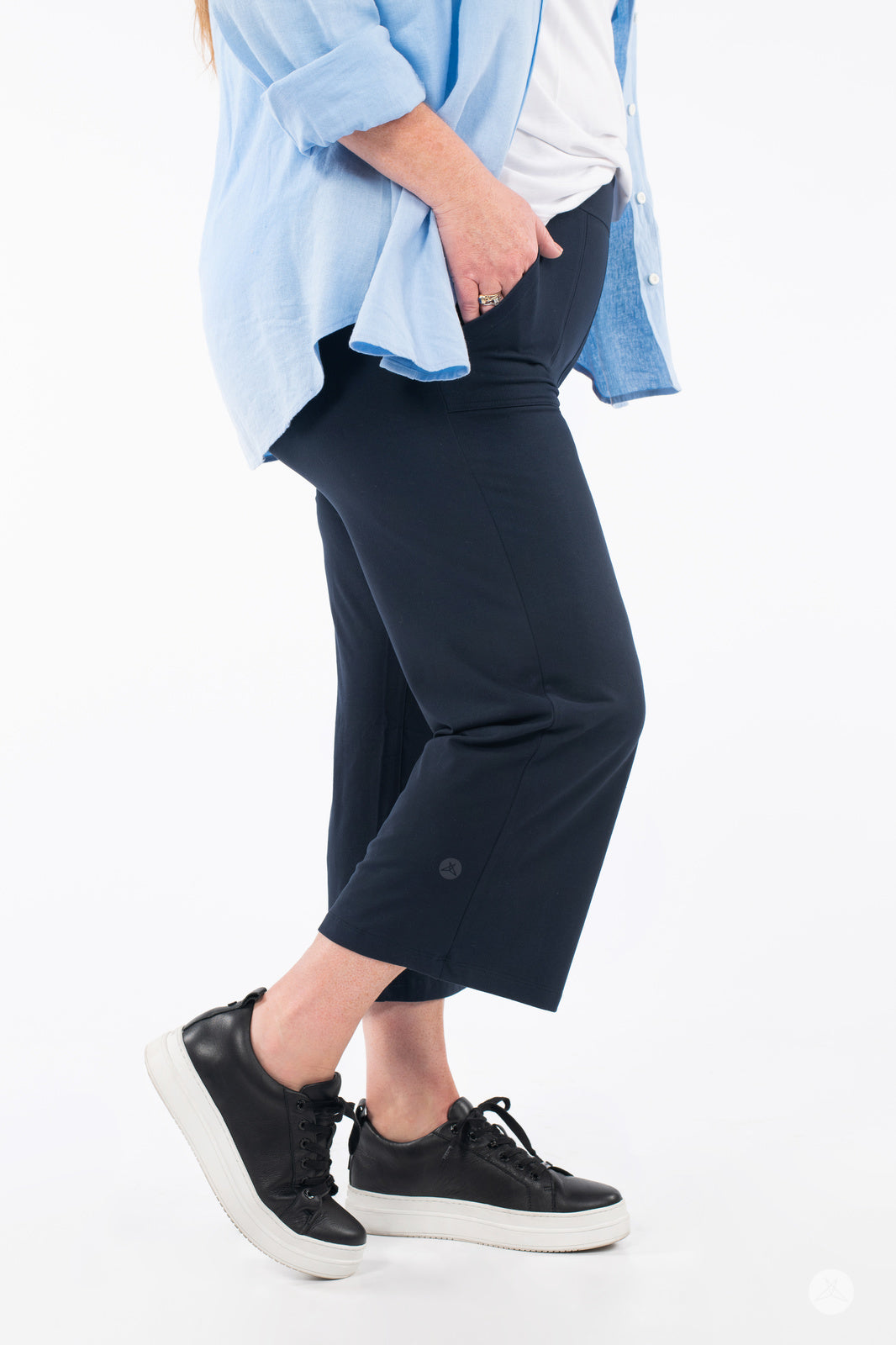 Side view of person wearing SweetLegs High-Waist Wide Leg Crops in black with black sneakers and light blue top