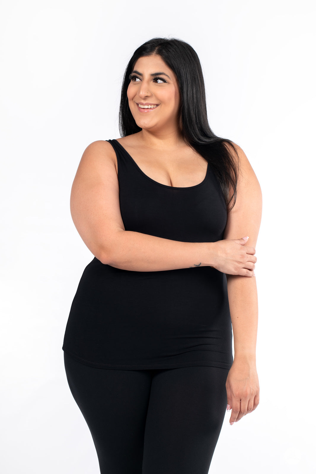 Smiling woman wearing black Classic Tank by SweetLegs Canada with black leggings on white background
