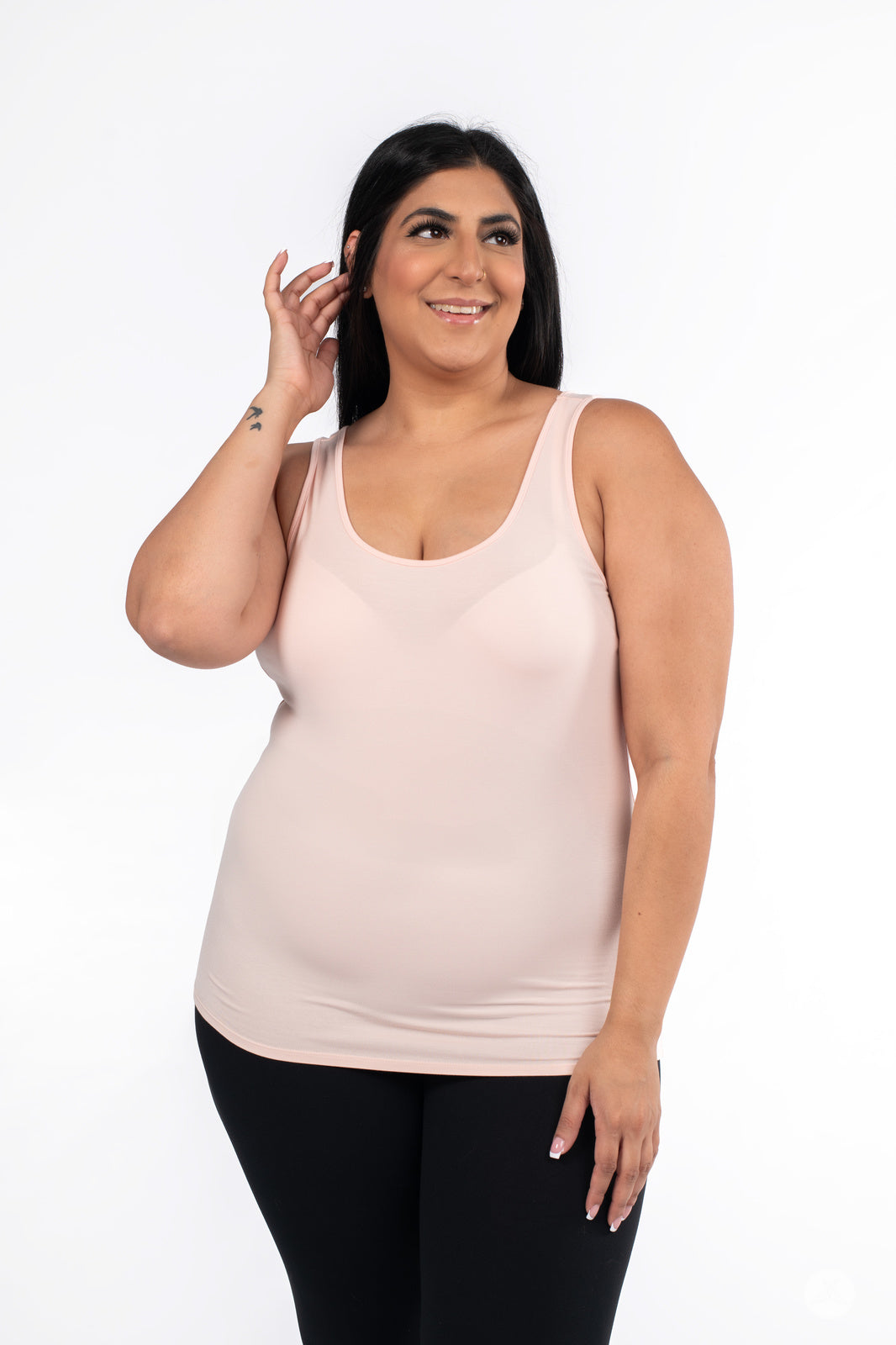 Plus-size model smiling wearing SweetLegs Canada Classic Tank in latte with black leggings on white background