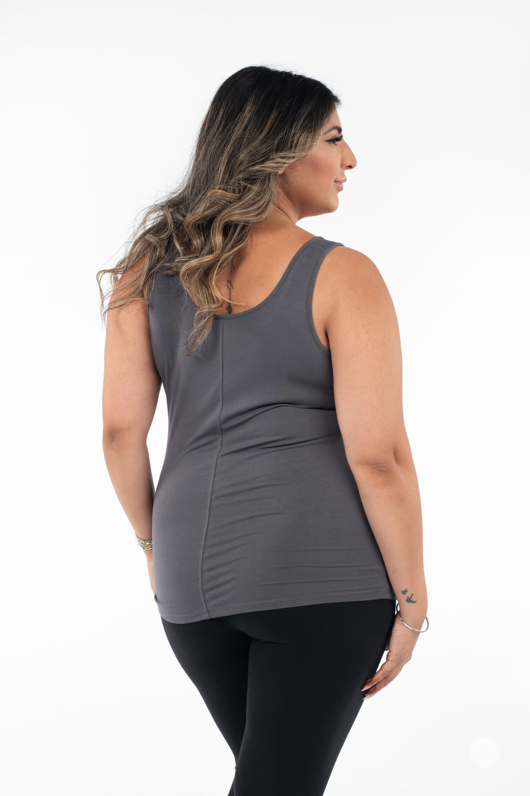 Plus-size model shown from back wearing SweetLegs Canada Classic Tank in grey with black pants on white background