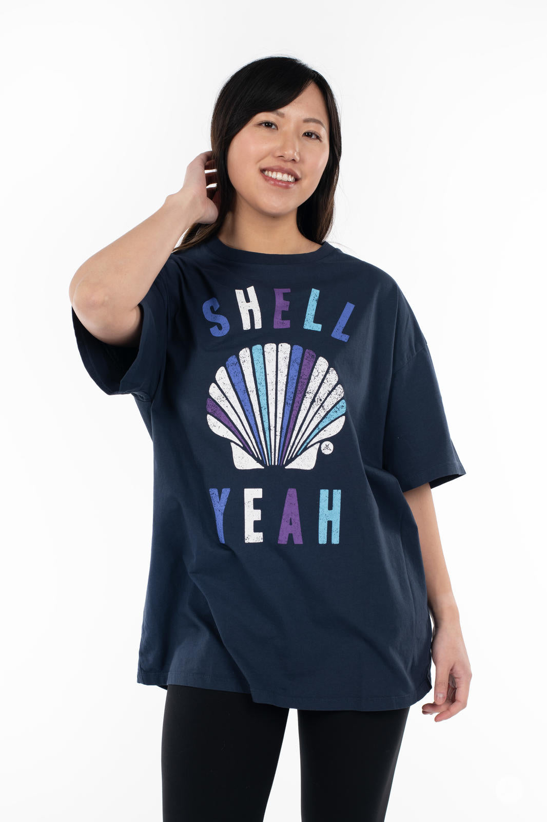 Woman wearing SweetTops Vintage Graphic Tee in navy with shell design and playful affirmation text "Shell Yeah