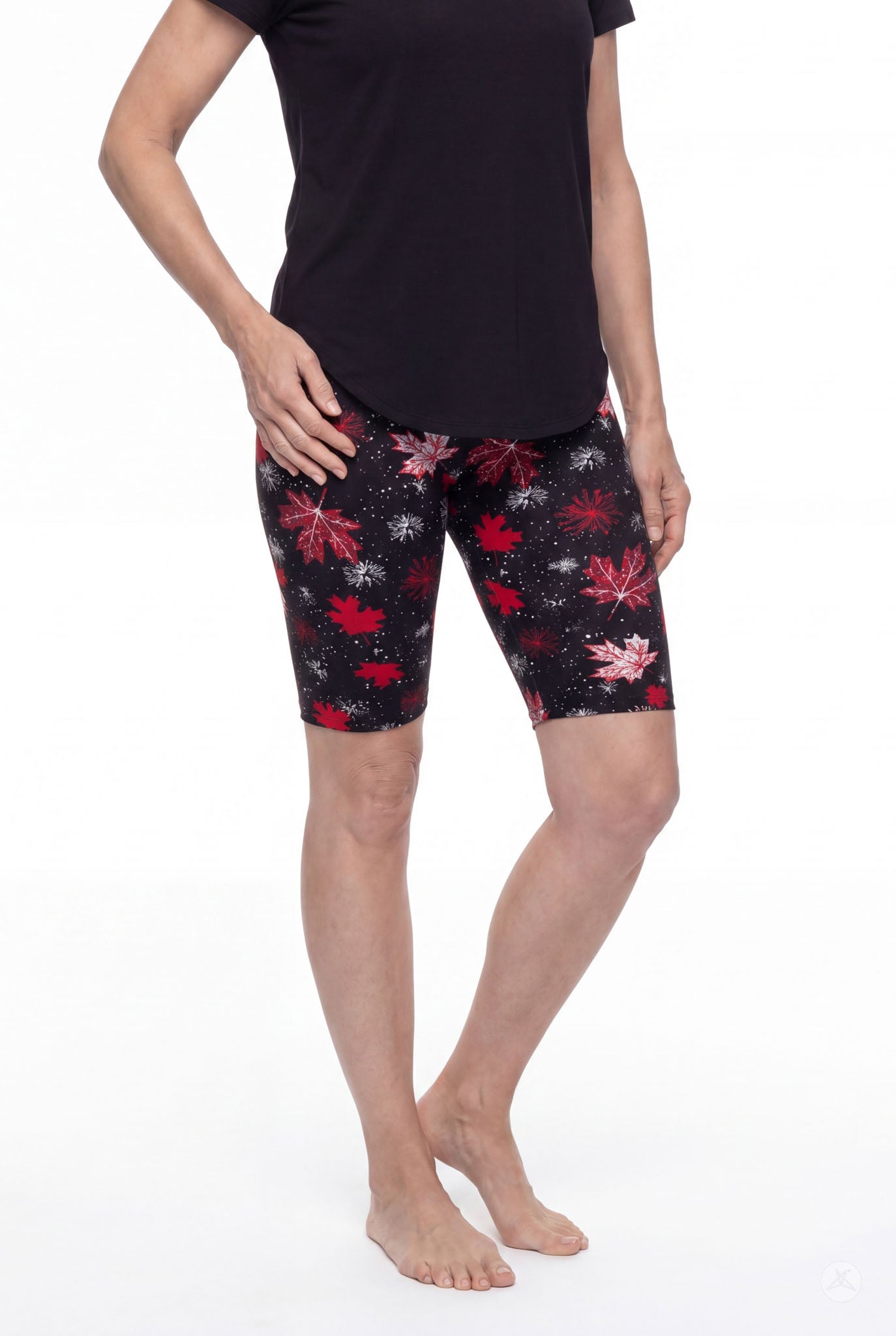 Woman wearing SweetLegs Maple Mood Biker Shorts with red leaf pattern and black top standing barefoot front view