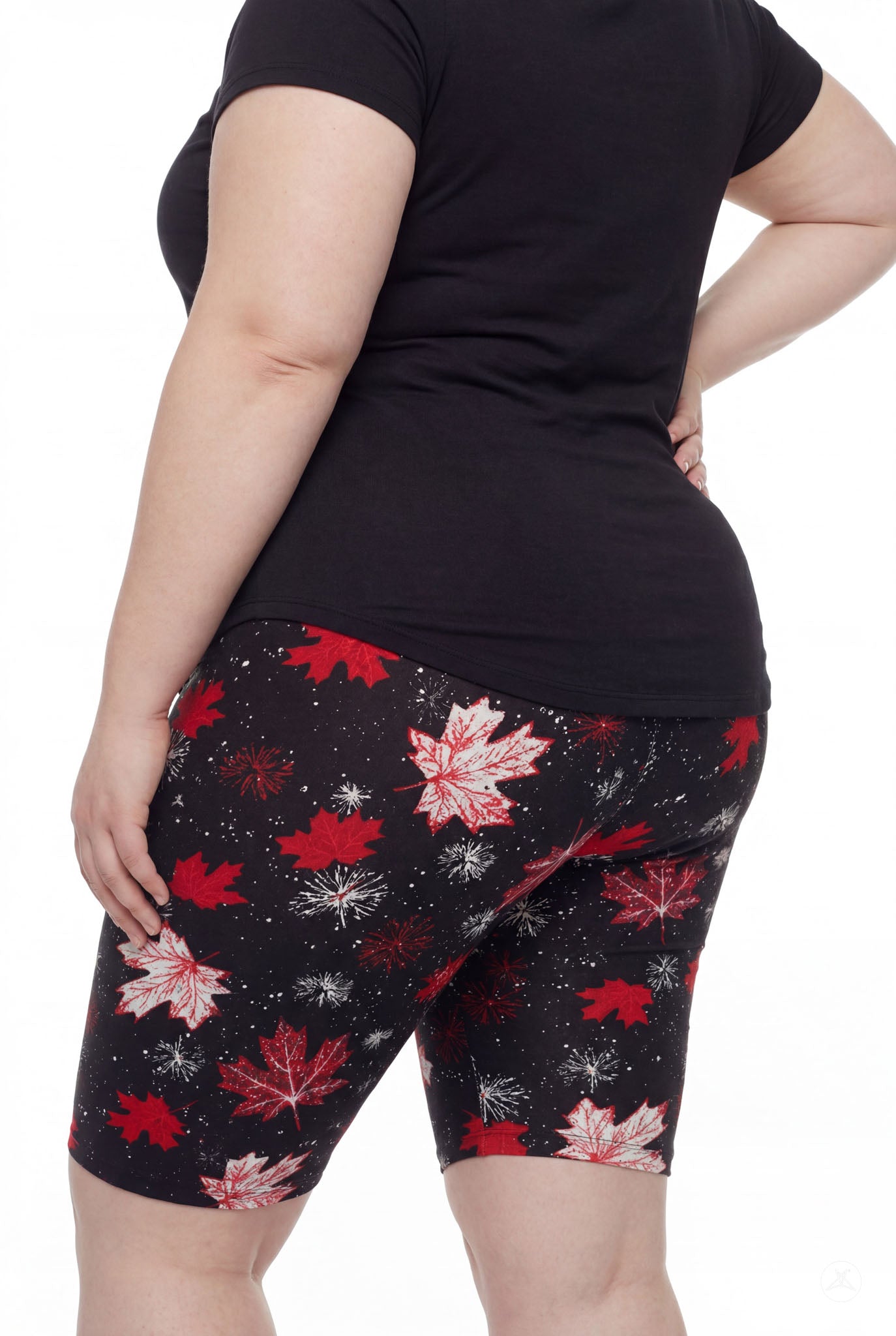 Plus size woman in SweetLegs Maple Mood Biker Shorts with red maple leaf print and black t-shirt rear view