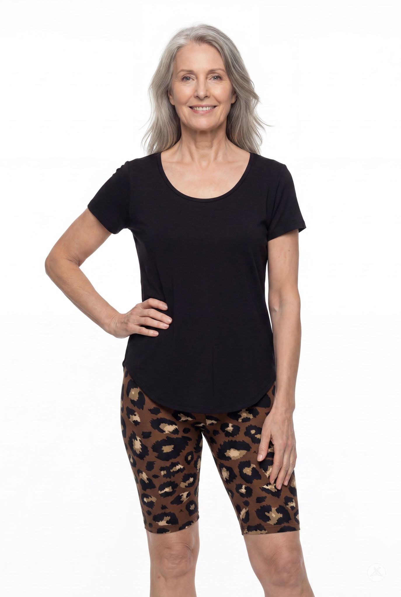 Smiling woman wearing SweetLegs Mocha Spots Biker Shorts with leopard print and black short sleeve top front view
