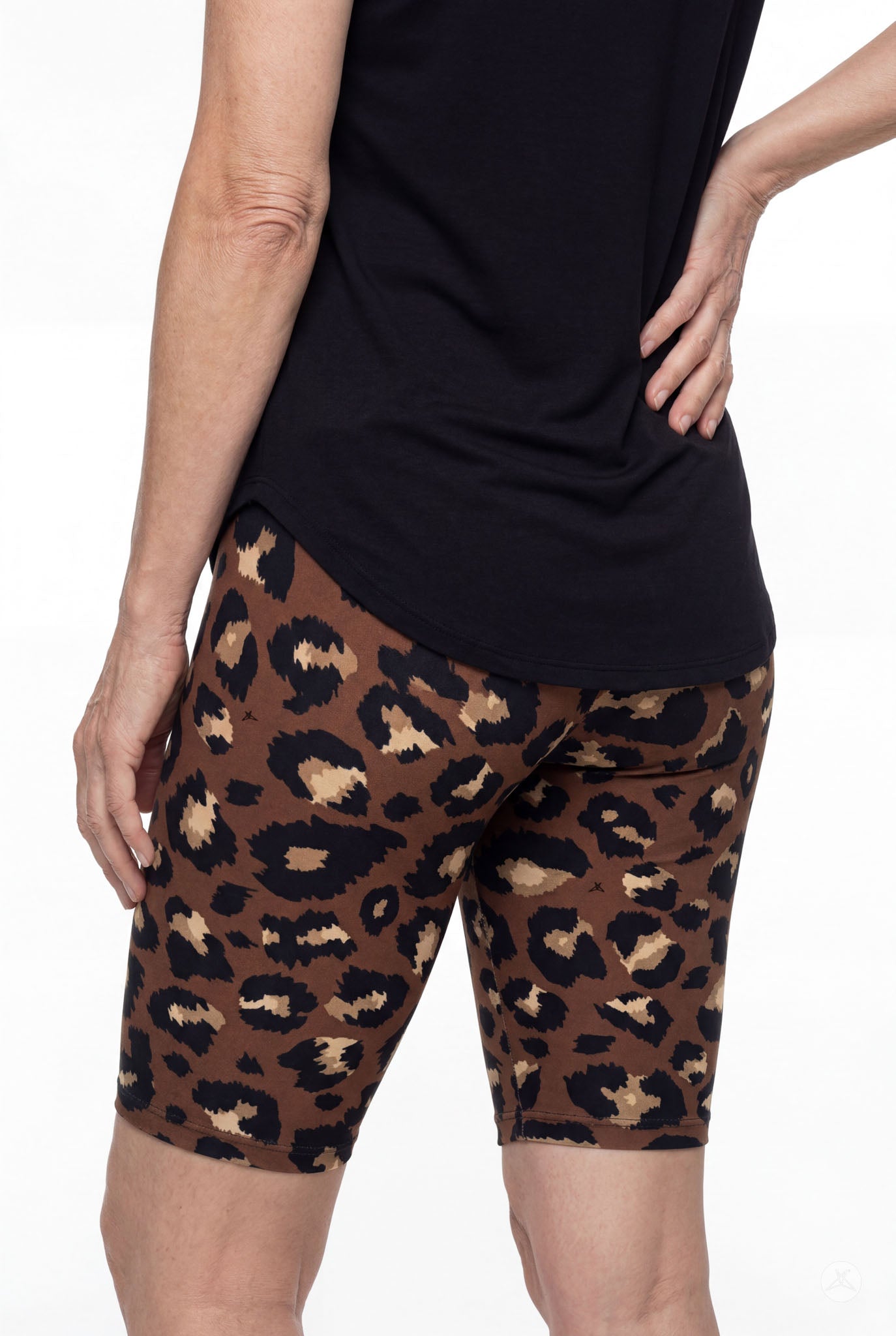 Rear view of woman wearing SweetLegs Mocha Spots Biker Shorts with brown and black leopard pattern and black top