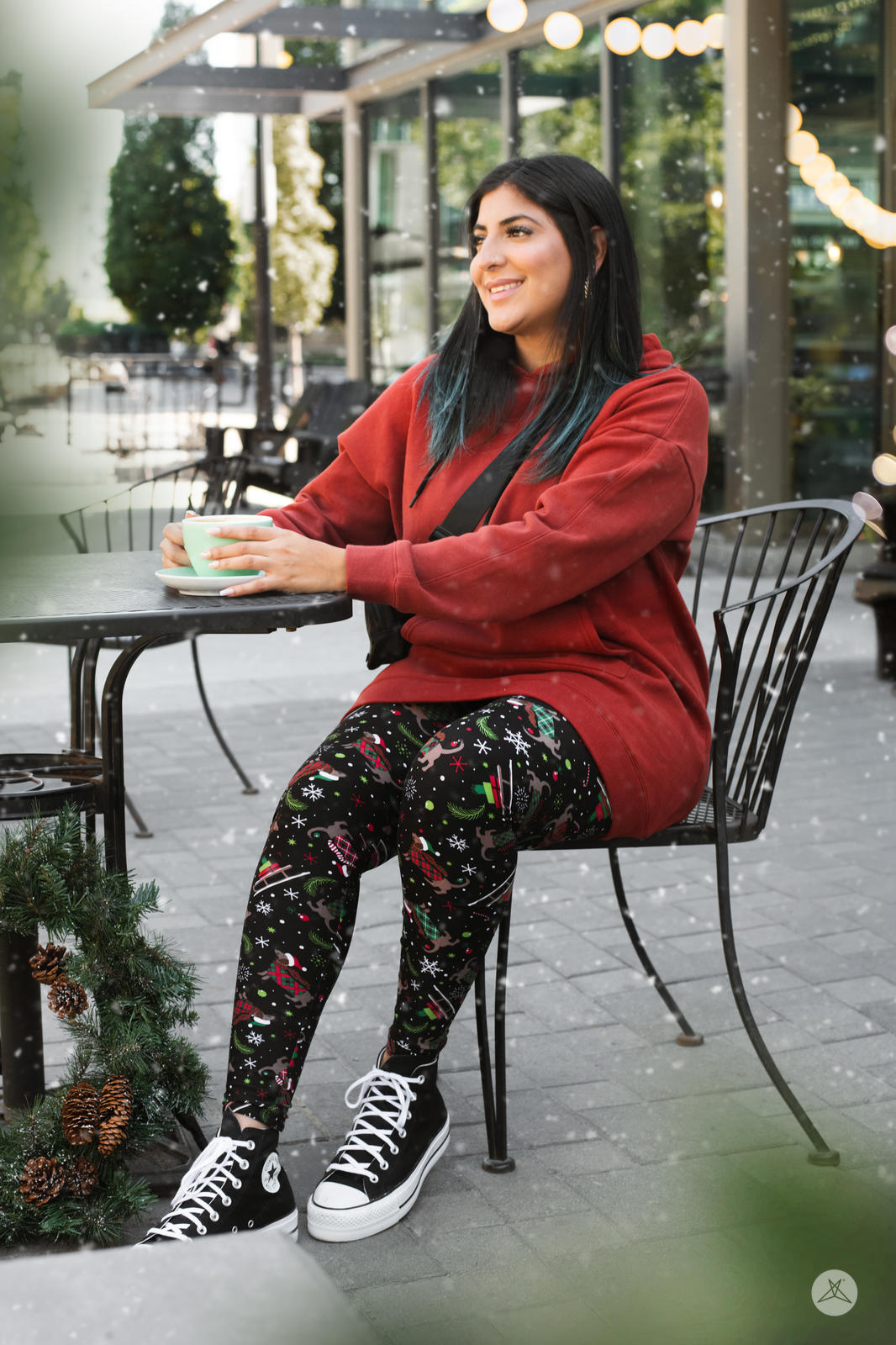 Woman sitting outdoors wearing SweetLegs Happy Pawlidays leggings with Christmas dogs and festive holiday patterns