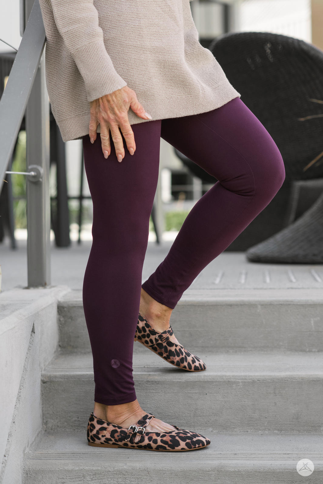 Close-up side view of legs wearing SweetLegs Blackberry High-Waisted Leggings paired with leopard print flats outdoors