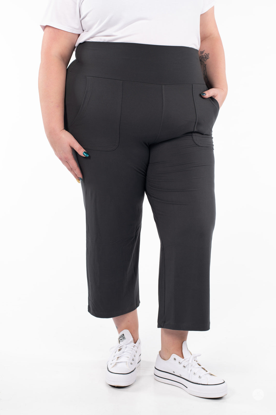 Plus-size model wearing SweetLegs High-Waist Wide Leg Crops in black with front pockets and white sneakers, cropped view