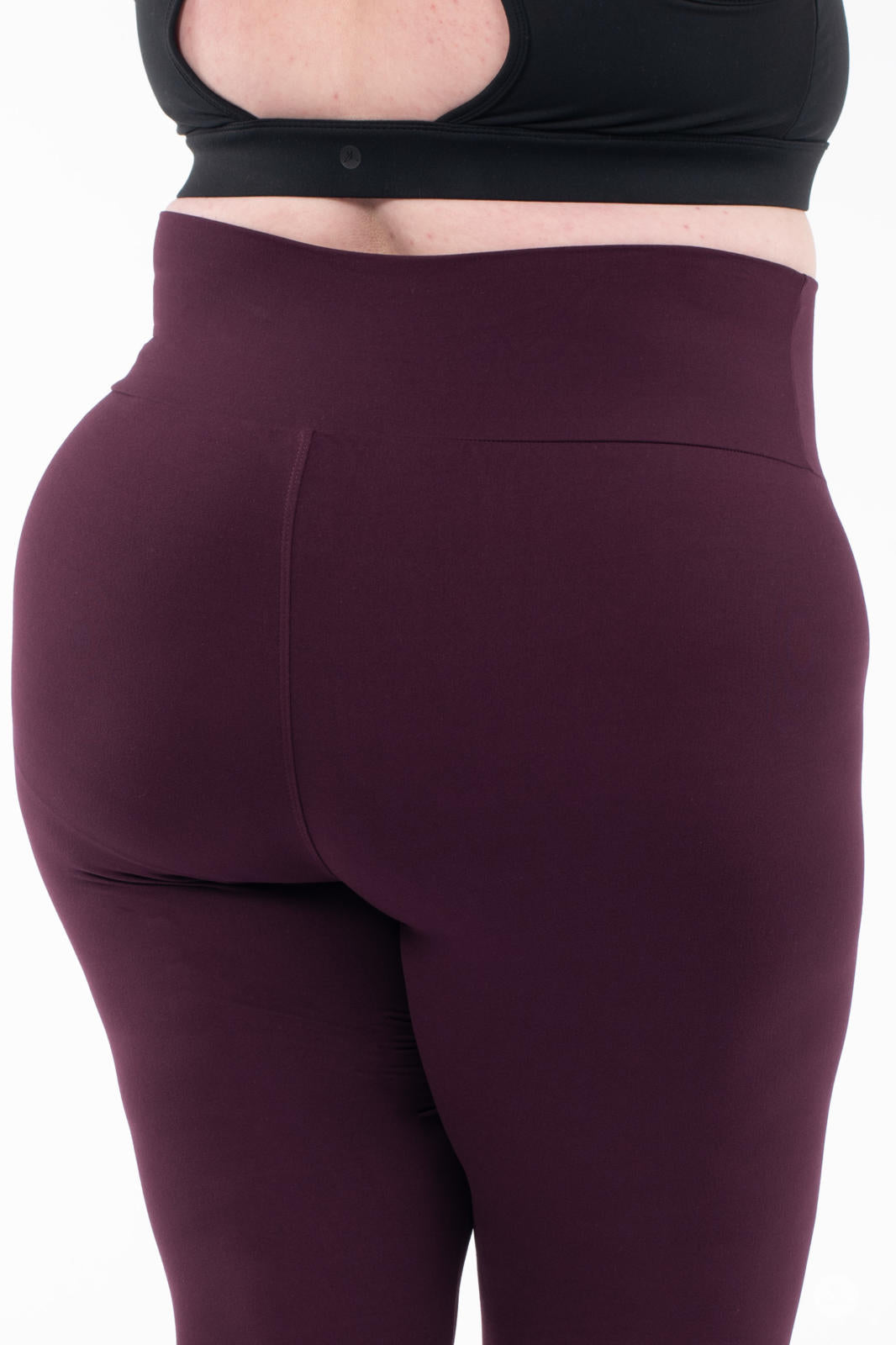 Rear close-up of SweetLegs Blackberry High-Waisted Leggings in deep rich purple on plus-size model without top visible
