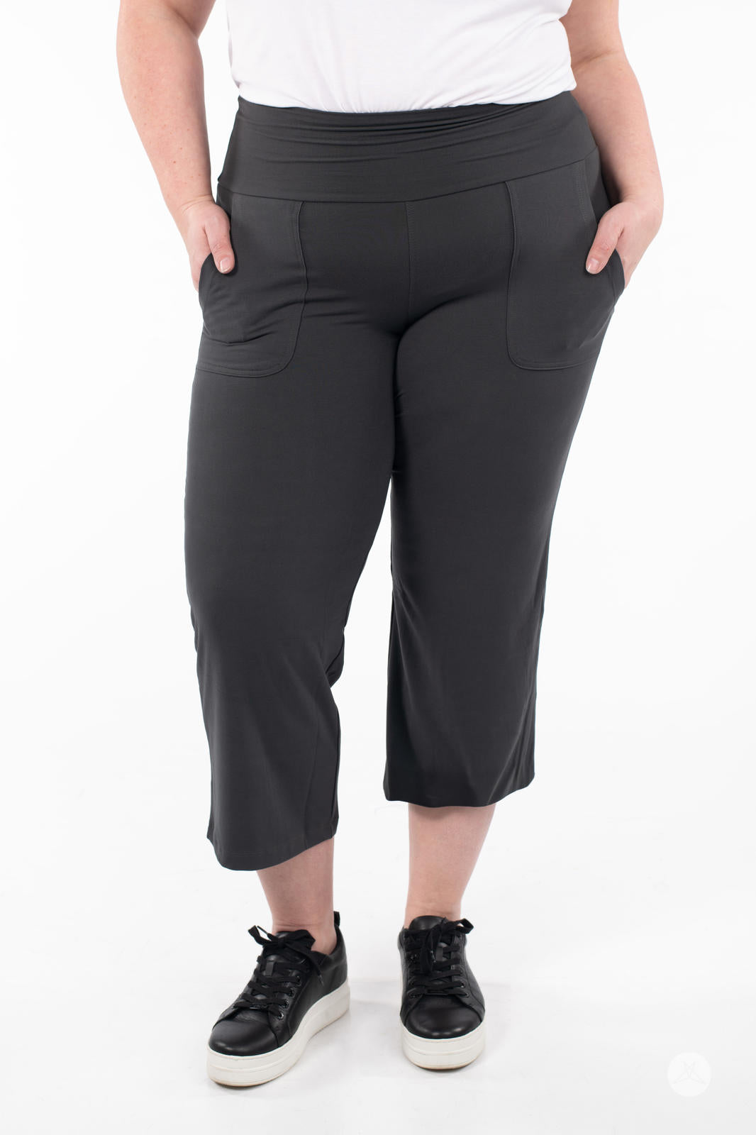 Front view of plus-size model wearing SweetLegs High-Waist Wide Leg Crops in black with hand pockets and sneakers