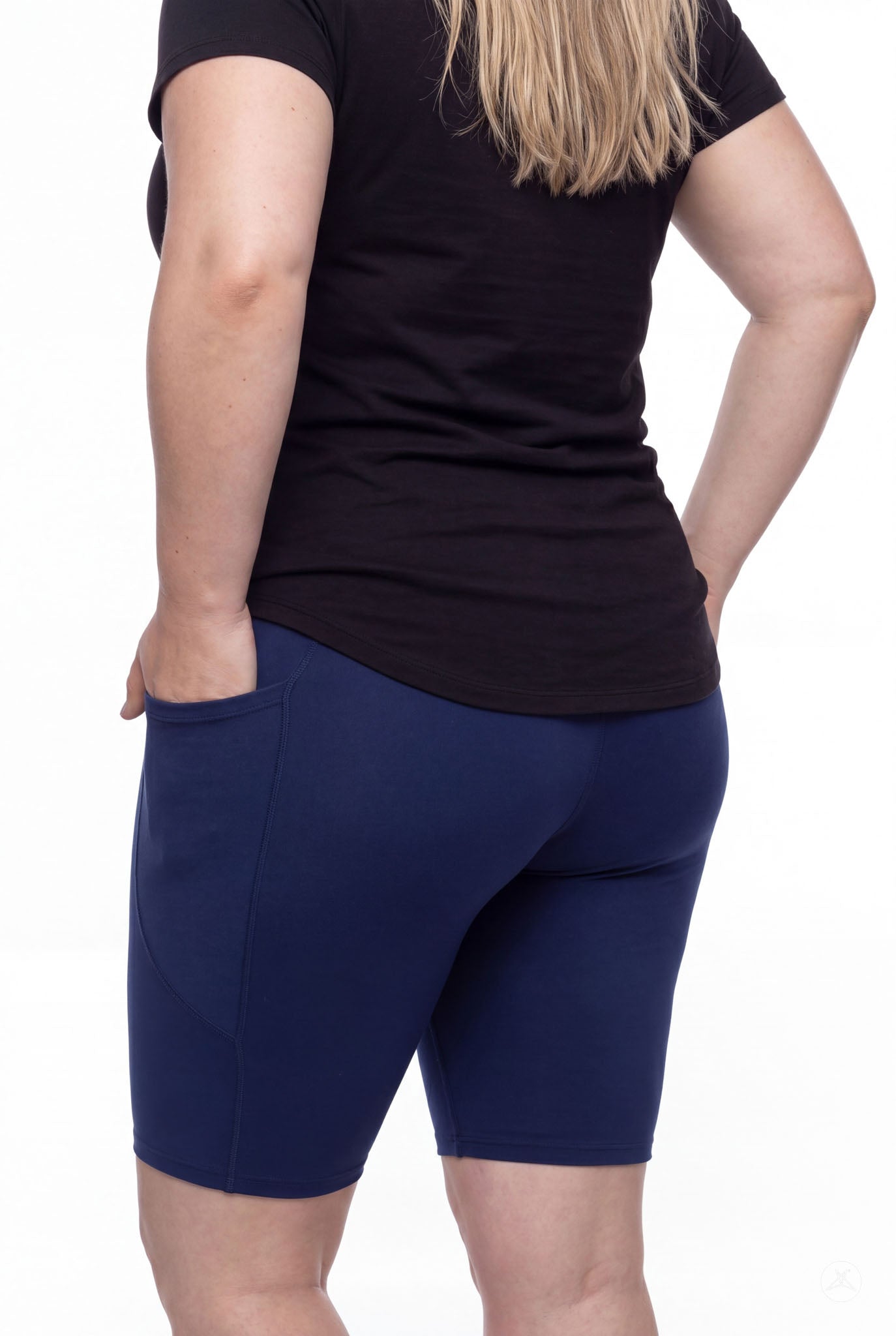 Woman wearing SweetLegs Still Water Pocket Biker Shorts in navy showing side pocket and smooth fit from back view