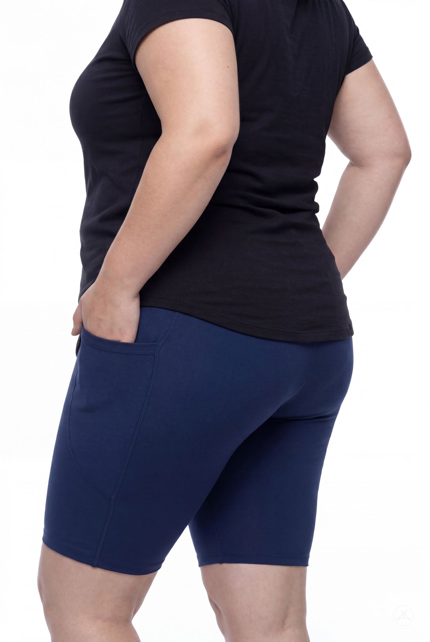 Plus size woman wearing SweetLegs Still Water Pocket Biker Shorts in navy showing side pocket and smooth fit from back angle
