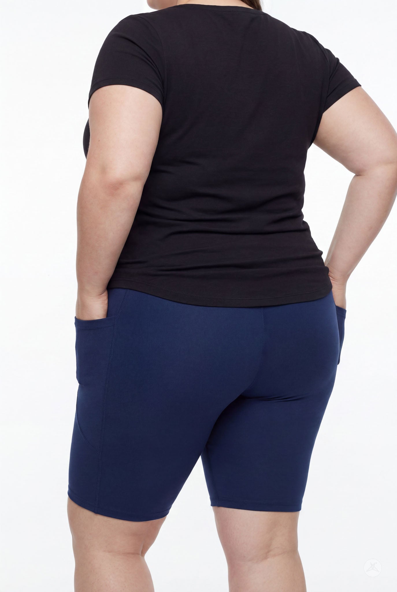 Plus size model wearing SweetLegs Still Water Pocket Biker Shorts in navy showing back pockets and smooth fit from behind